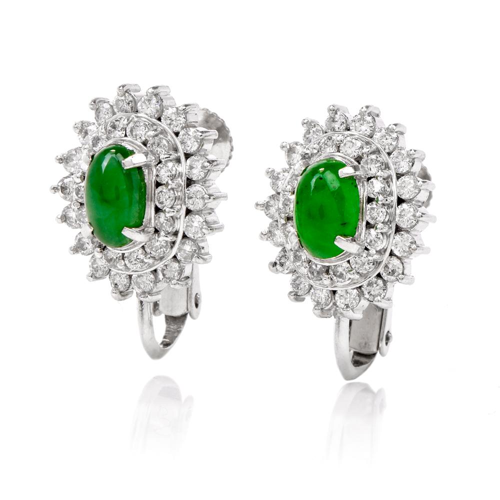 These elegant jade and diamond earrings are crafted in solid platinum. Featuring two prominent cabochon jades approx. 0.75 carats. Surrounded by a double halo of round-cut diamonds weighing approx. 0.78 carats, graded H-I color, and VS1-VS2 clarity.