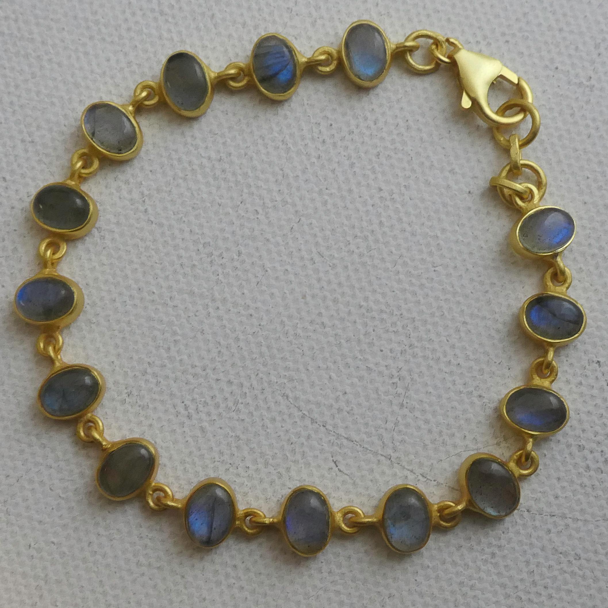 Esta cautivadora pulsera exhibe cabujones ovales de 4x6 mm de labradorita natural, cada piedra resplandeciente con destellos azules, verdes y dorados, un efecto óptico conocido como labradorescencia. Misteriosas pero refinadas, estas gemas cambian
