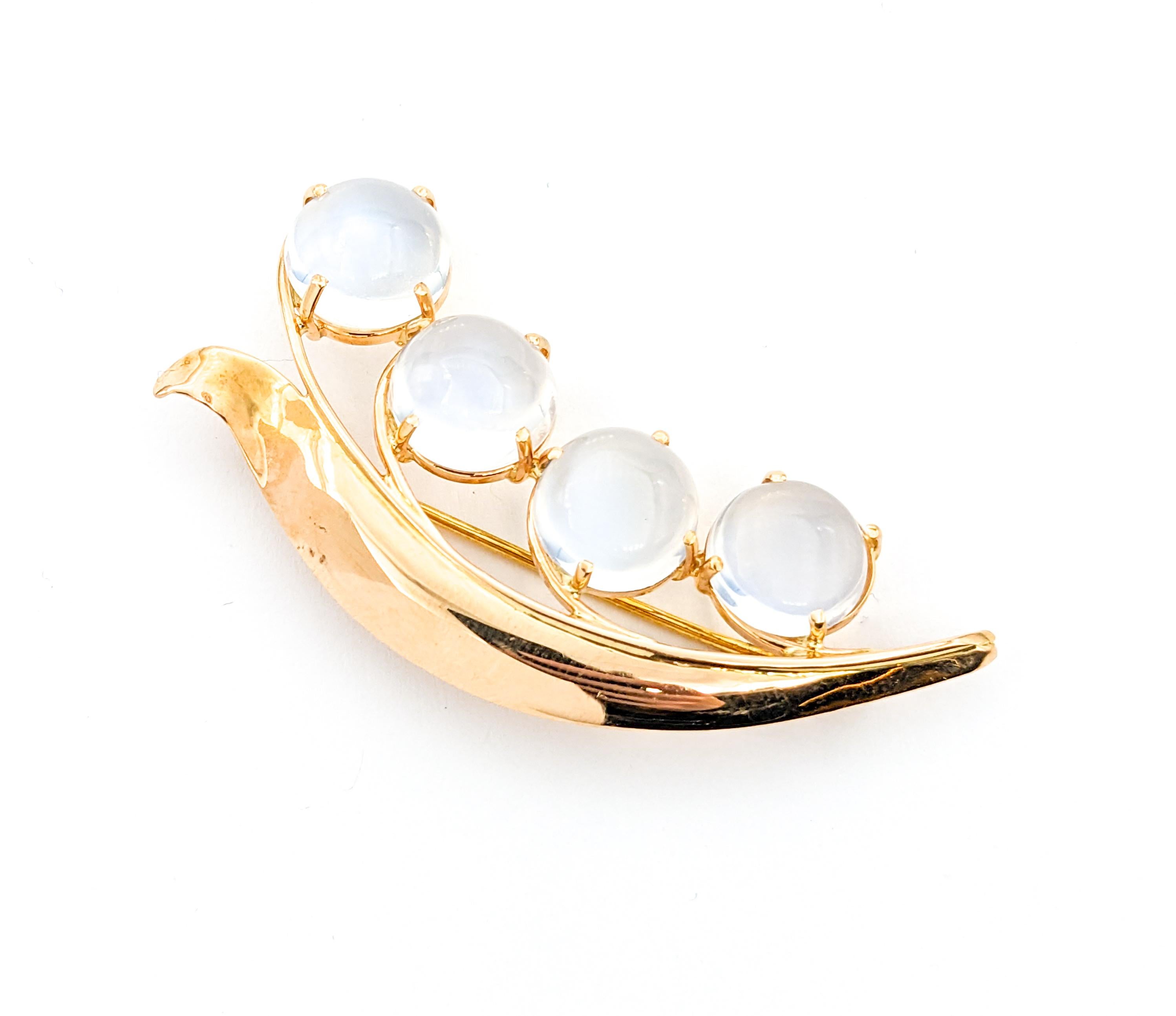 Mid-Century Cabochon Moonstone Vine Brooch In Yellow Gold

Introducing a captivating Vintage Brooch with a Mid-Century Leaf Motif, adorned with a row of four stunning 10-11mm Cabochon Moonstones. This exquisite piece is crafted in 14k yellow gold
