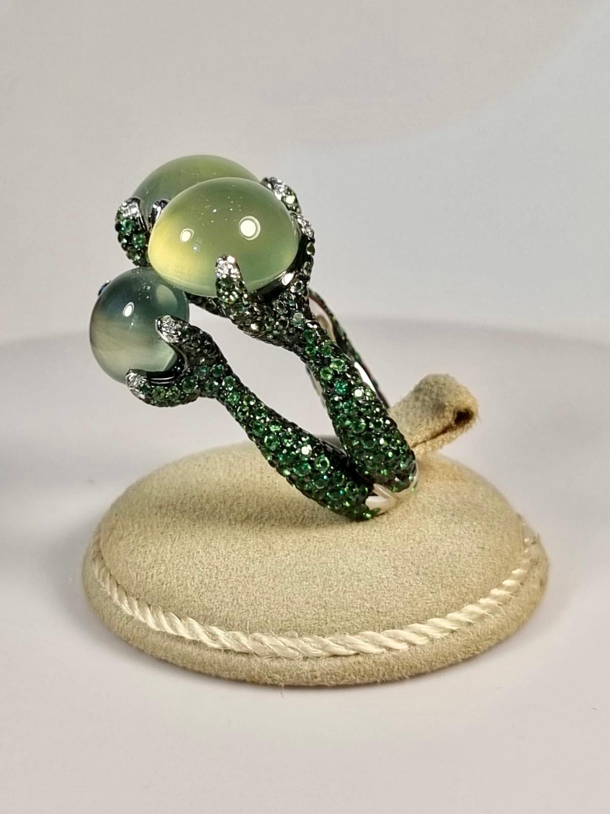 Cabochon Prehnite  with green garnet and diamonds in 18k white gold 
Central Phrenites total  31.72 cts
Green Garnets and diamonds 0.11 cts
Size Europe 53, USA 6.5 
Ring weight 18.59gr

Prehnite is a rare gemstone that forms as a result of