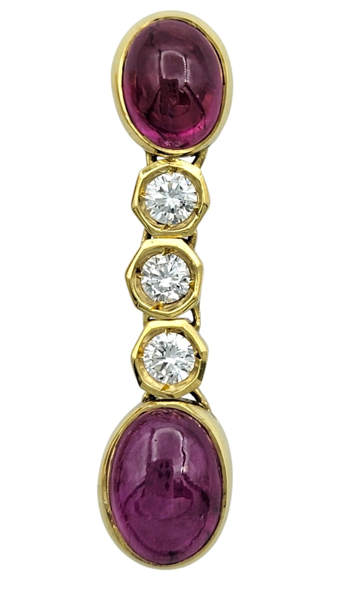 Luminoso e sofisticato, questo splendido paio di orecchini pendenti è realizzato in oro giallo 18 carati. Ogni orecchino presenta due accattivanti cabochon di rubino naturale di forma ovale, le cui tonalità di rosso intenso emanano ricchezza ed