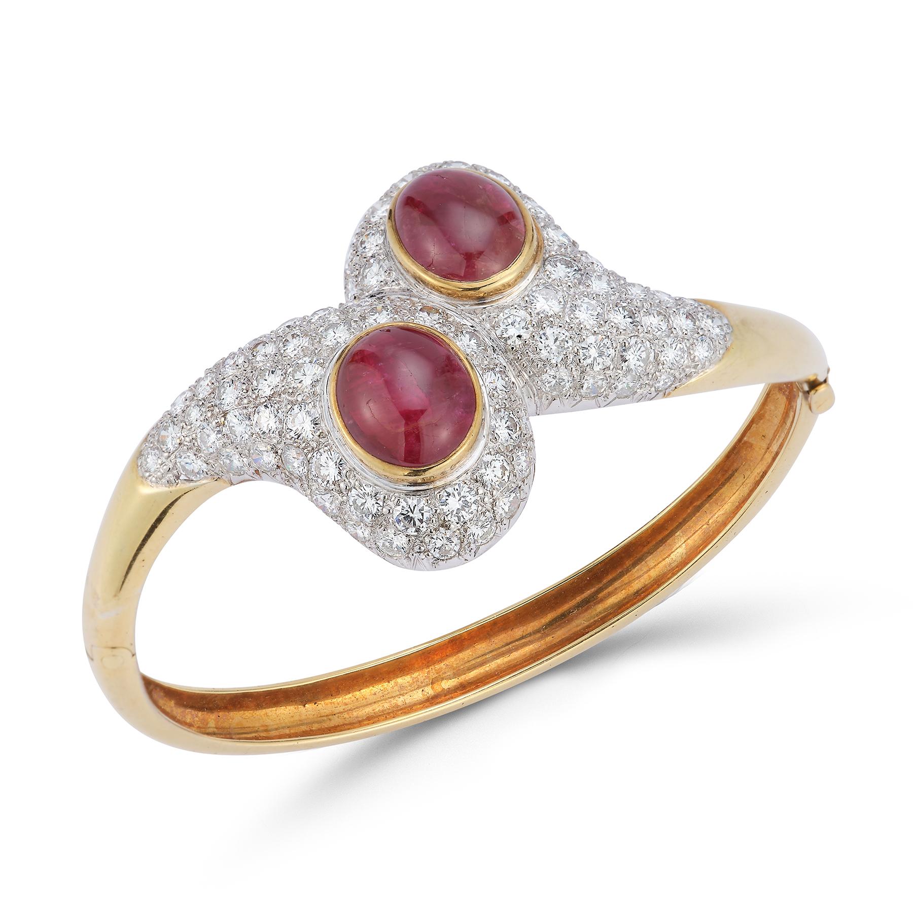 Cabochon Ruby and Diamond Crossover Bangle

 2 cabochon center rubies surrounded by 86 round cut diamonds set in 18k yellow gold.

Measurements: 2.5