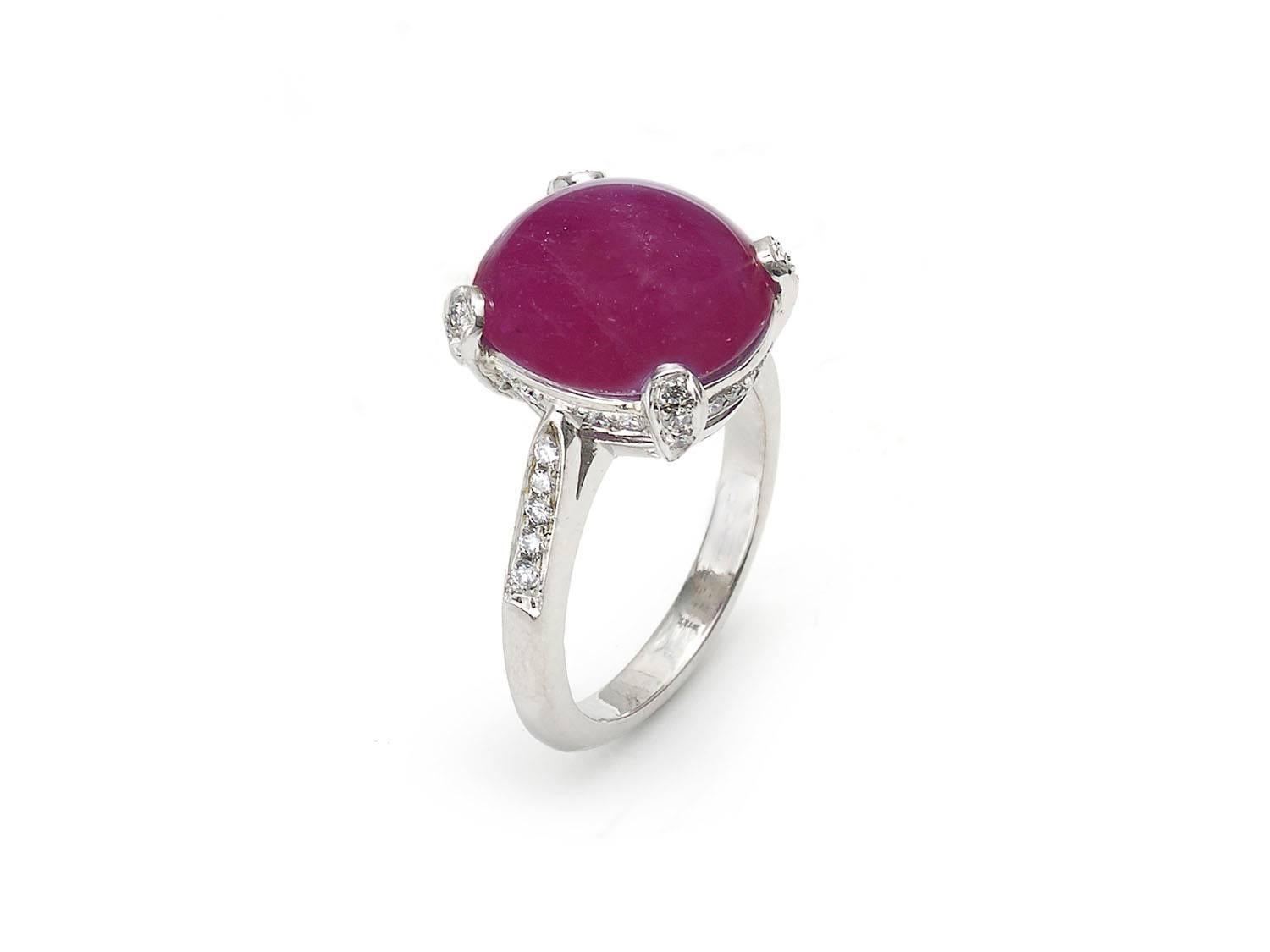A ruby and diamond ring, set with a semi translucent, oval cabochon-cut ruby weighing an estimated 8.60ct, in a four claw setting, with brilliant-cut diamond set shoulders, claws and bezel. Finger size UK K½, US 5½