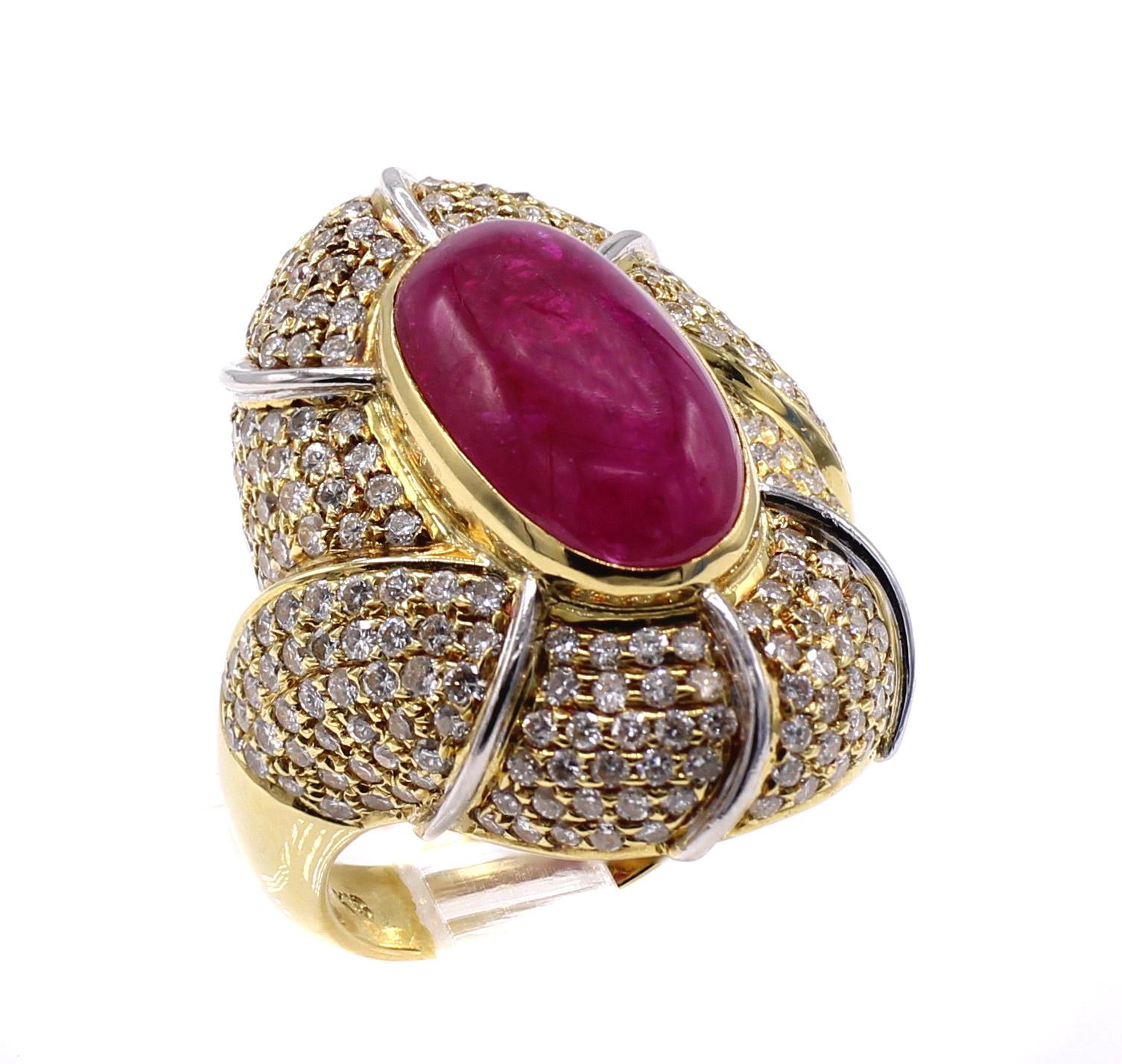 Beautifully designed and masterfully handcrafted this 18 karat yellow gold ring features a pigeon blood red elongated cabochon ruby weighing 7.55 carats, pave set with bright white round brilliant cut diamonds weighing 1.81 carats. The exact weights