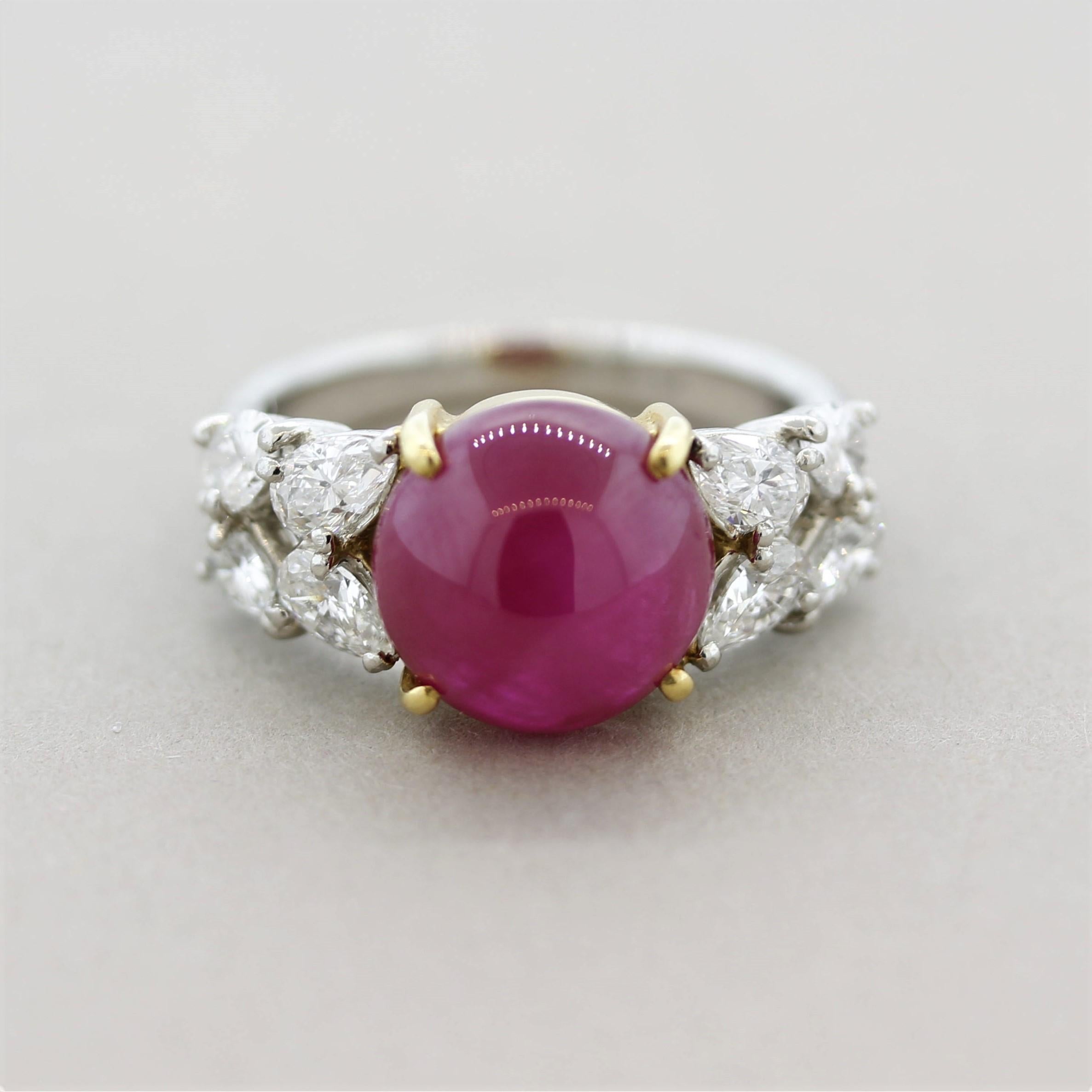 A luscious 6.30 carat ruby takes center stage! The cabochon gem has a bright evenly red color with excellent luster as light rolls across its surface. It is accented by 8 large pear-shape diamonds set on its sides weighing a total of 1.27 carats.