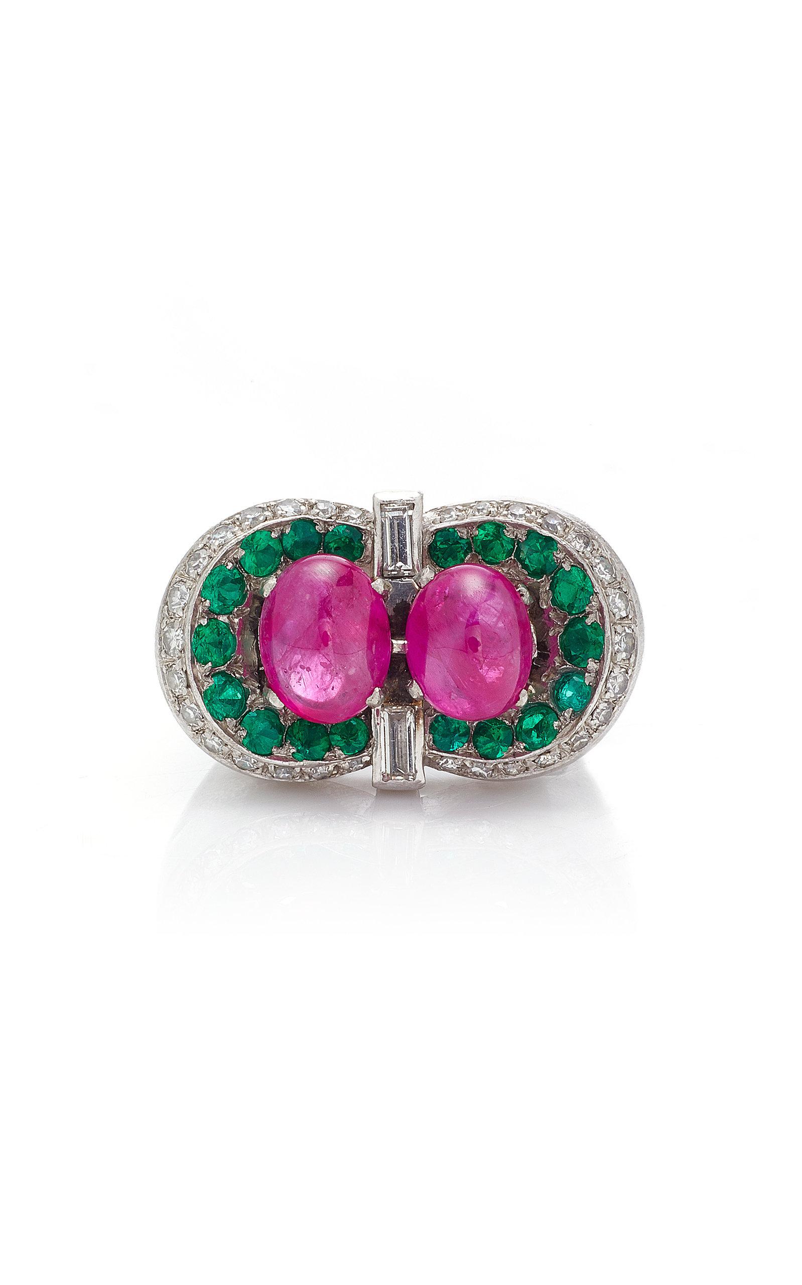 A powerful cocktail ring in 18kt white gold with two baguette cut and eighteen round brilliant cut diamonds (app. 1 ct total), emerald, highlighting two cabochon rubies. Made in Italy, circa 1970s.