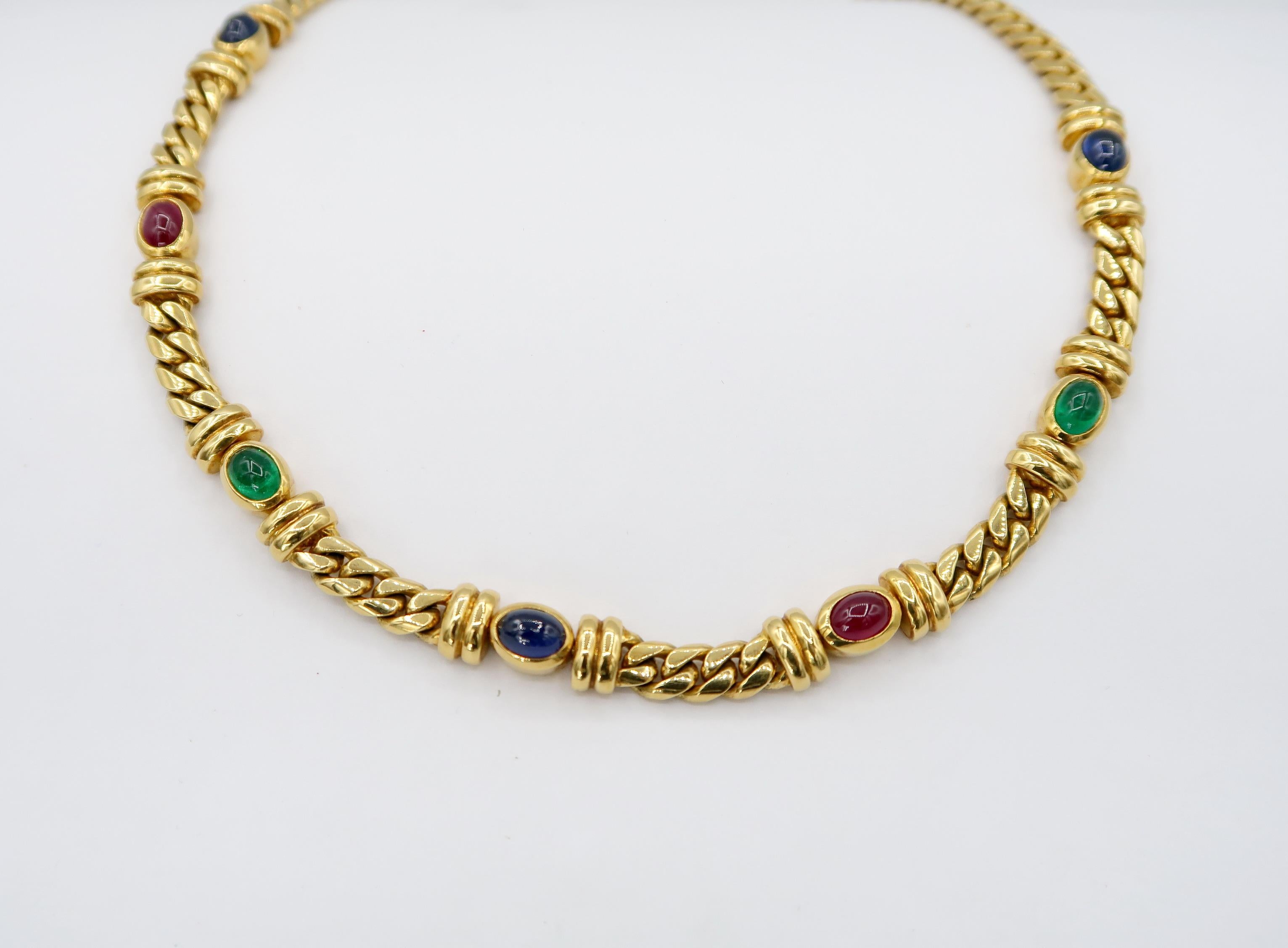 18K Yellow Gold Smooth Curb Chain Necklace Embellished with Bezel-Set Cabochon Precious Stones: Ruby Sapphire and Emerald.

The necklace comes with a hidden double-lock box clasp.

Gold: 18K Yellow Gold, 80.311 g
Ruby, Sapphire and Emerald: approx.