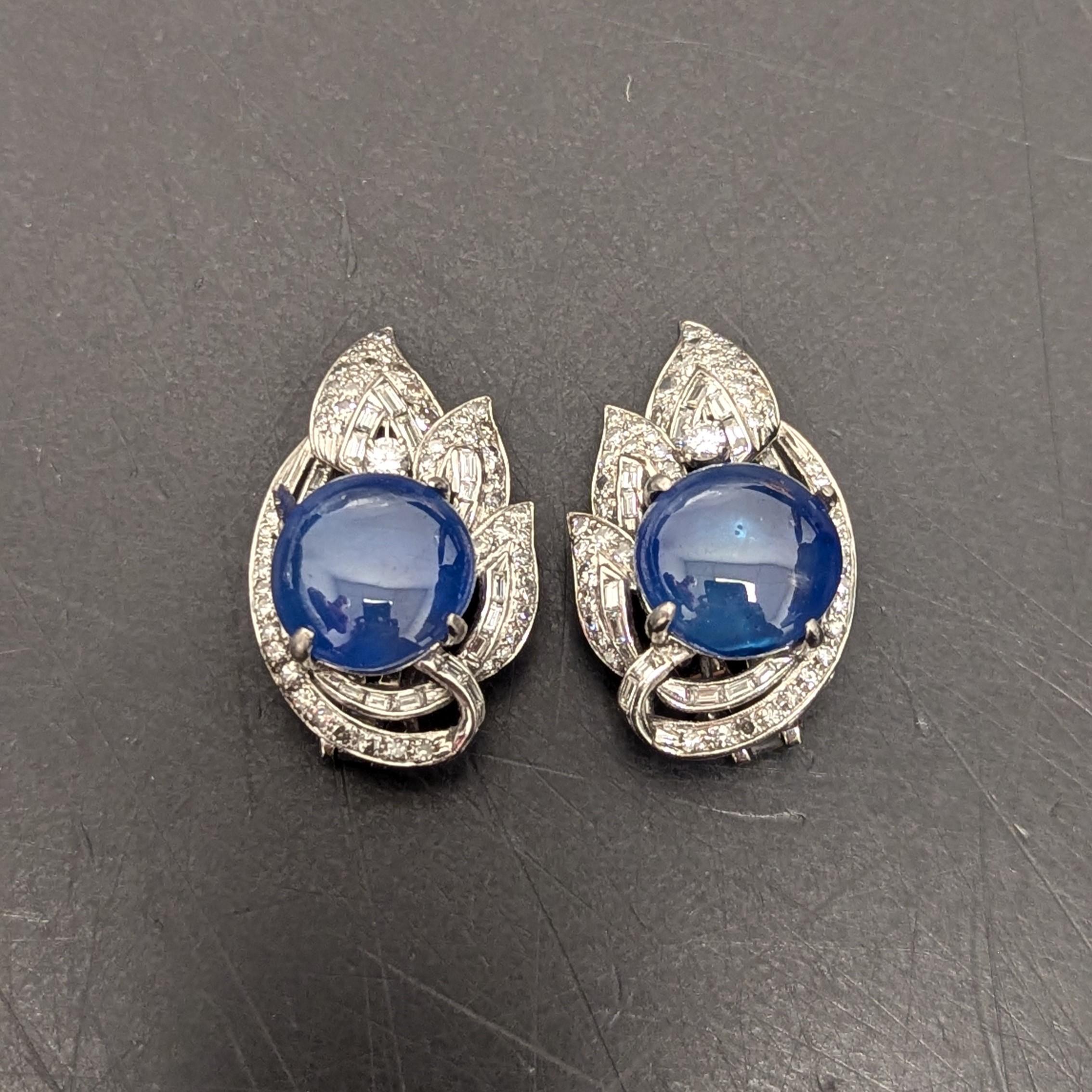 Ces boucles d'oreilles composées de saphirs et de diamants à facettes multiples présentent des saphirs birmans en cabochon d'un bleu bleu profond entourés d'environ 5 à 6 ct de diamants de formes et de tailles différentes. 
