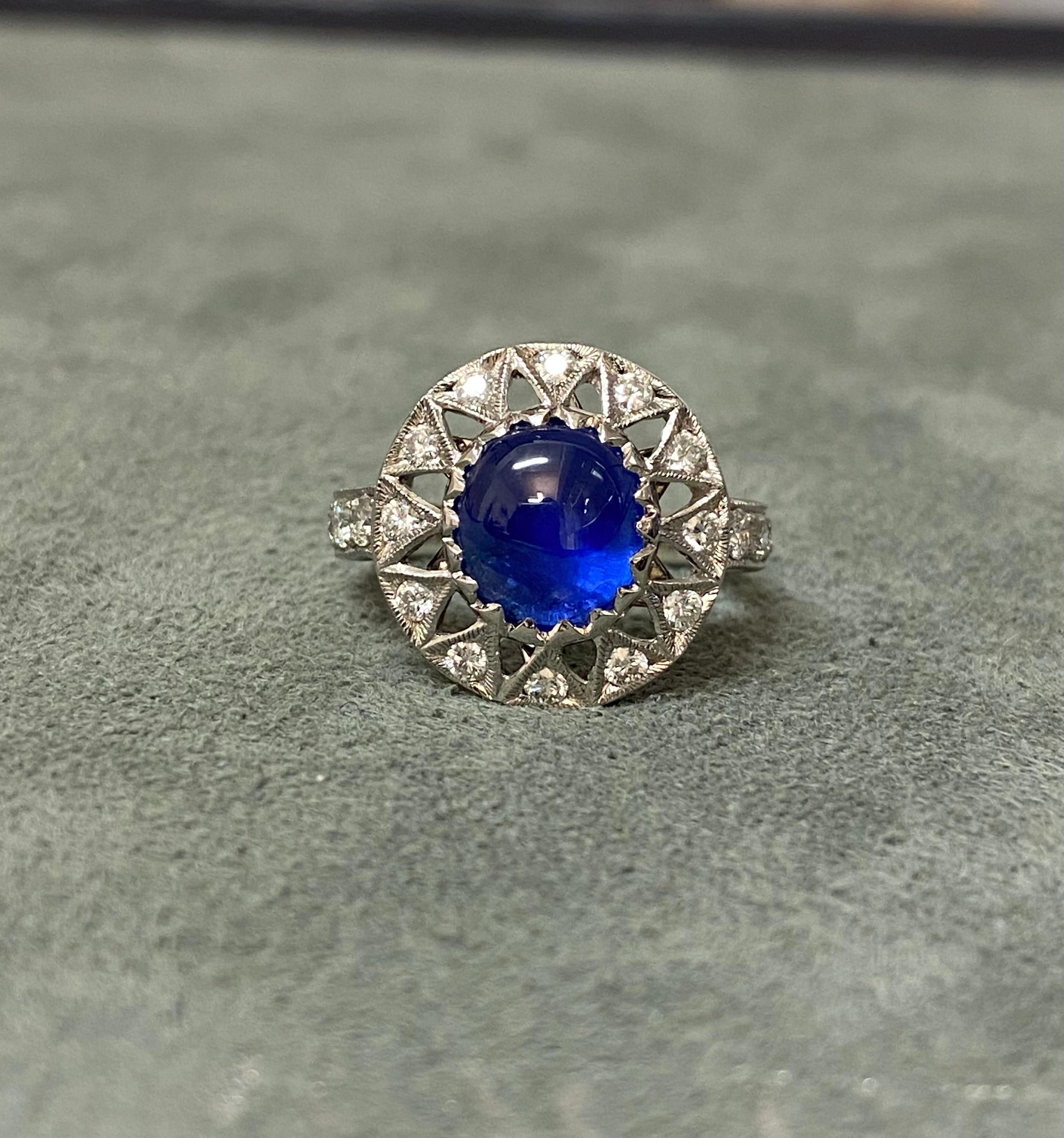 Ein wunderschöner blauer Saphir im Cabochon-Schliff von 3,85ct, besetzt mit Diamanten (0,64ct, G-H SI) in Weißgold. Der Saphir zeigt unter bestimmten Lichtverhältnissen einen leichten Stern (Asterismus). 