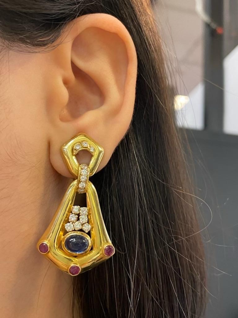 Cabochon Sapphire and Ruby Earrings 

Yellow gold dangle earrings set with 2 cabochon sapphires, 6 cabochon rubies, and 30 round cut diamonds. 

Diamonds weigh approximately 1.64 carats
Sapphires weigh approximately 3.49 carats
Rubies weigh