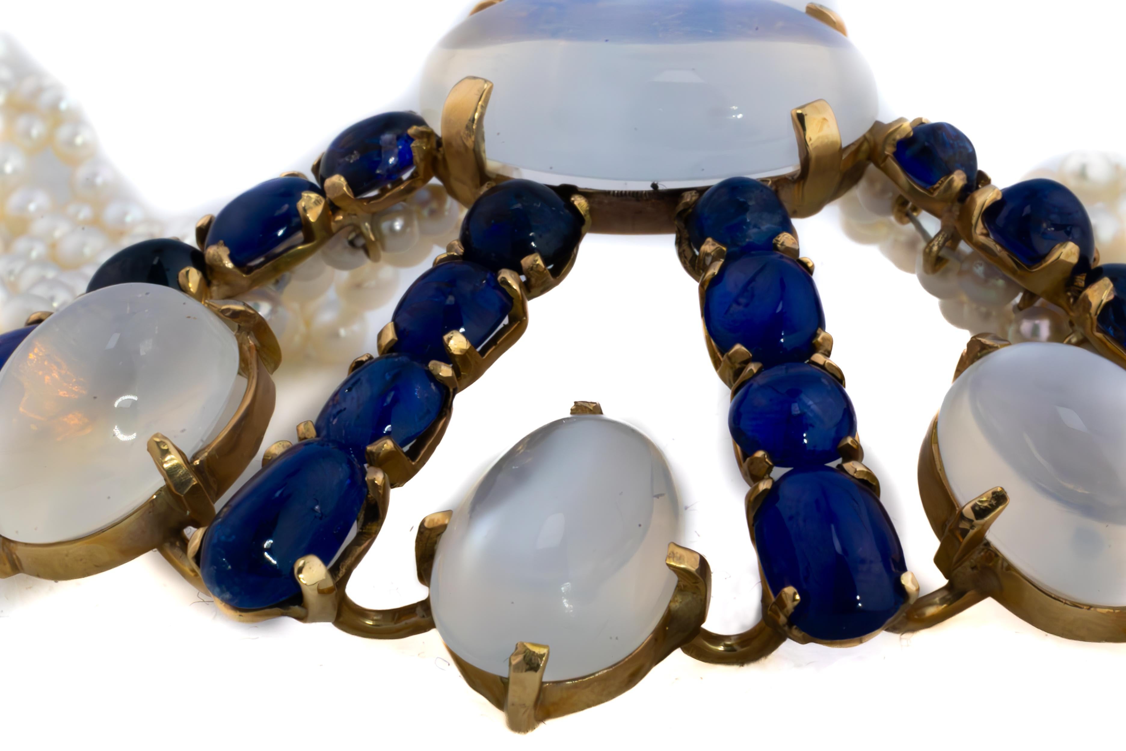Girocollo con zaffiro cabochon, pietra di luna e perle a più fili

Questa squisita collana di zaffiri e pietre di luna cabochon è un'accattivante dimostrazione di eleganza e charme. Con 16 zaffiri blu cabochon e 4 pietre di luna cabochon, la collana