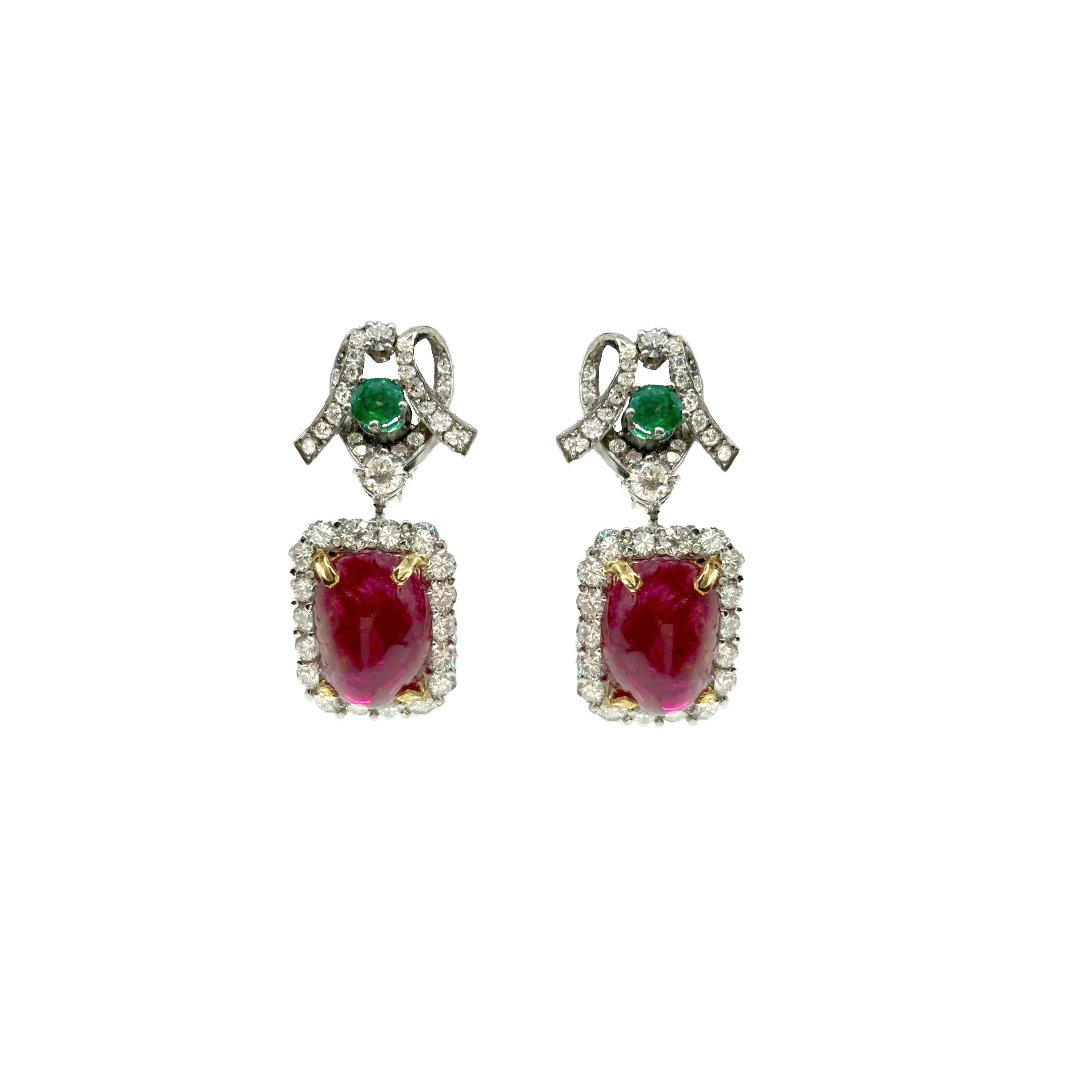 A beautiful pair of white gold drop earrings embellished with emeralds and diamonds, each suspending an 11.61 and 11.71 carat cabochon spinel. Circa 1960s.