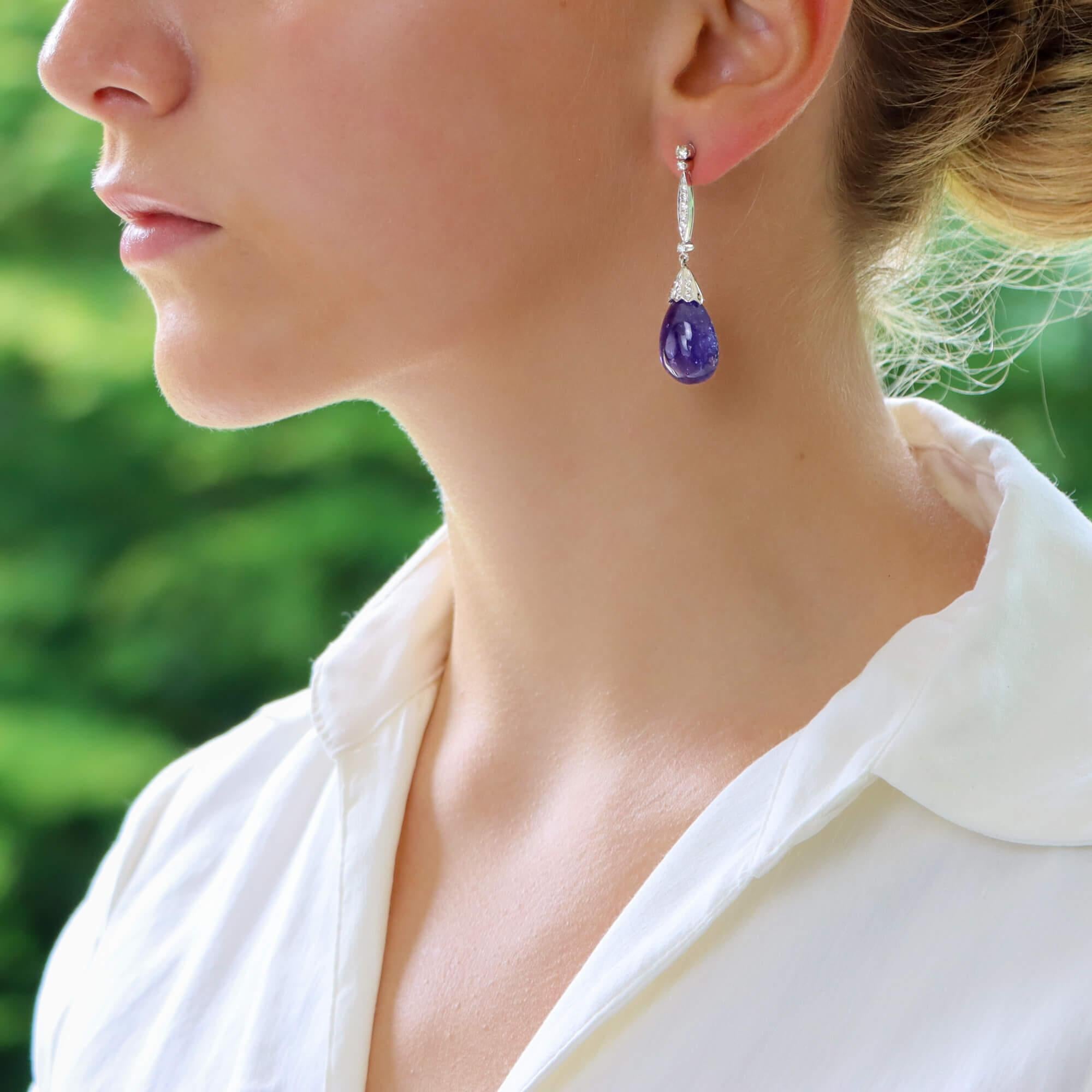 A stunning pair of cabochon tanzanite and diamond drop earrings in 18-karat white gold. 
The earrings are composed of a marquise-shaped surmount grain-set throughout with round brilliant-cut diamonds, flanked above by row claw-set round