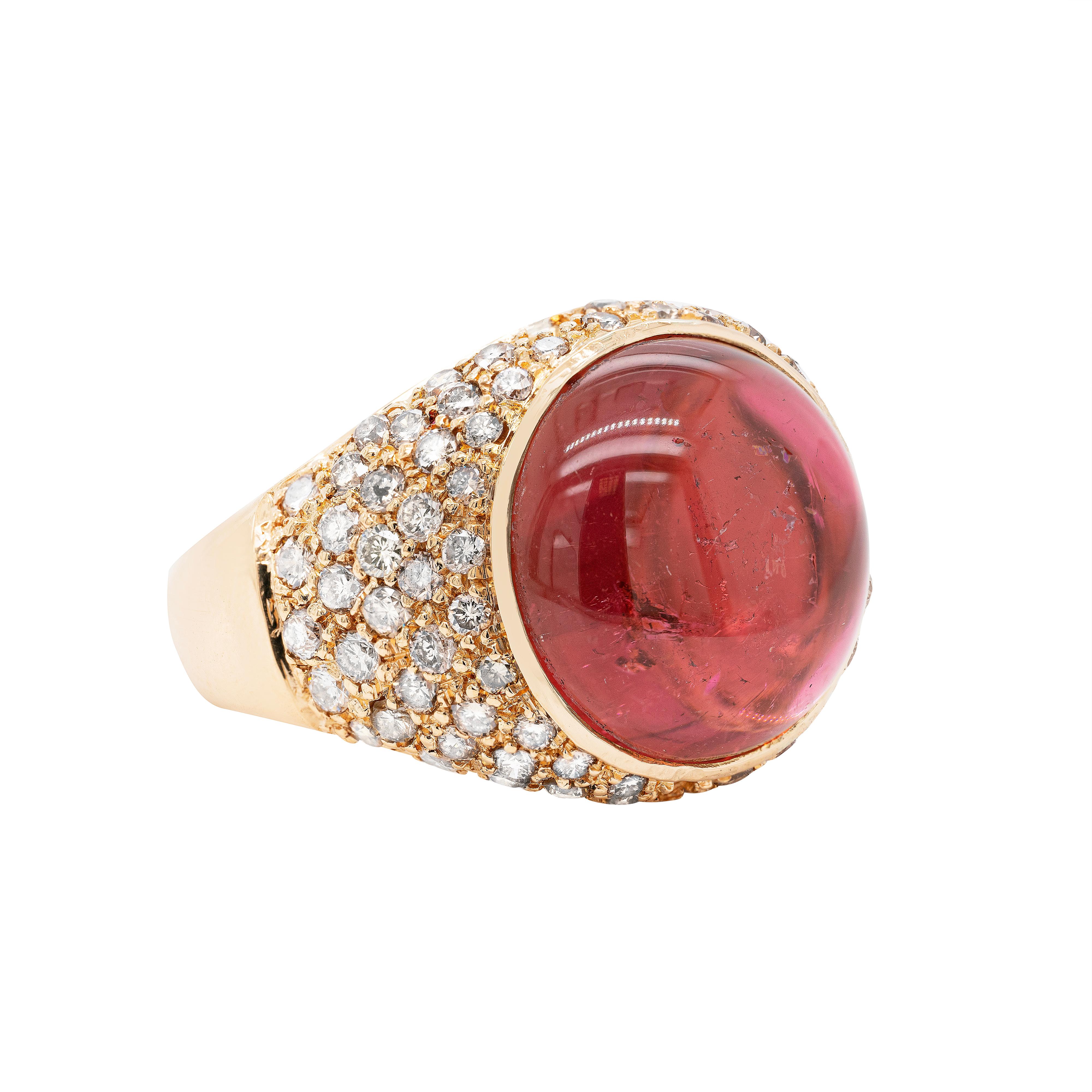Bold and beautiful, this cocktail ring features a vibrant cabochon tourmaline measuring 13.8mm, rub-over set in the centre in an 18 carat yellow gold open back mount. The gorgeous piece is further pavé set with fine quality round brilliant cut