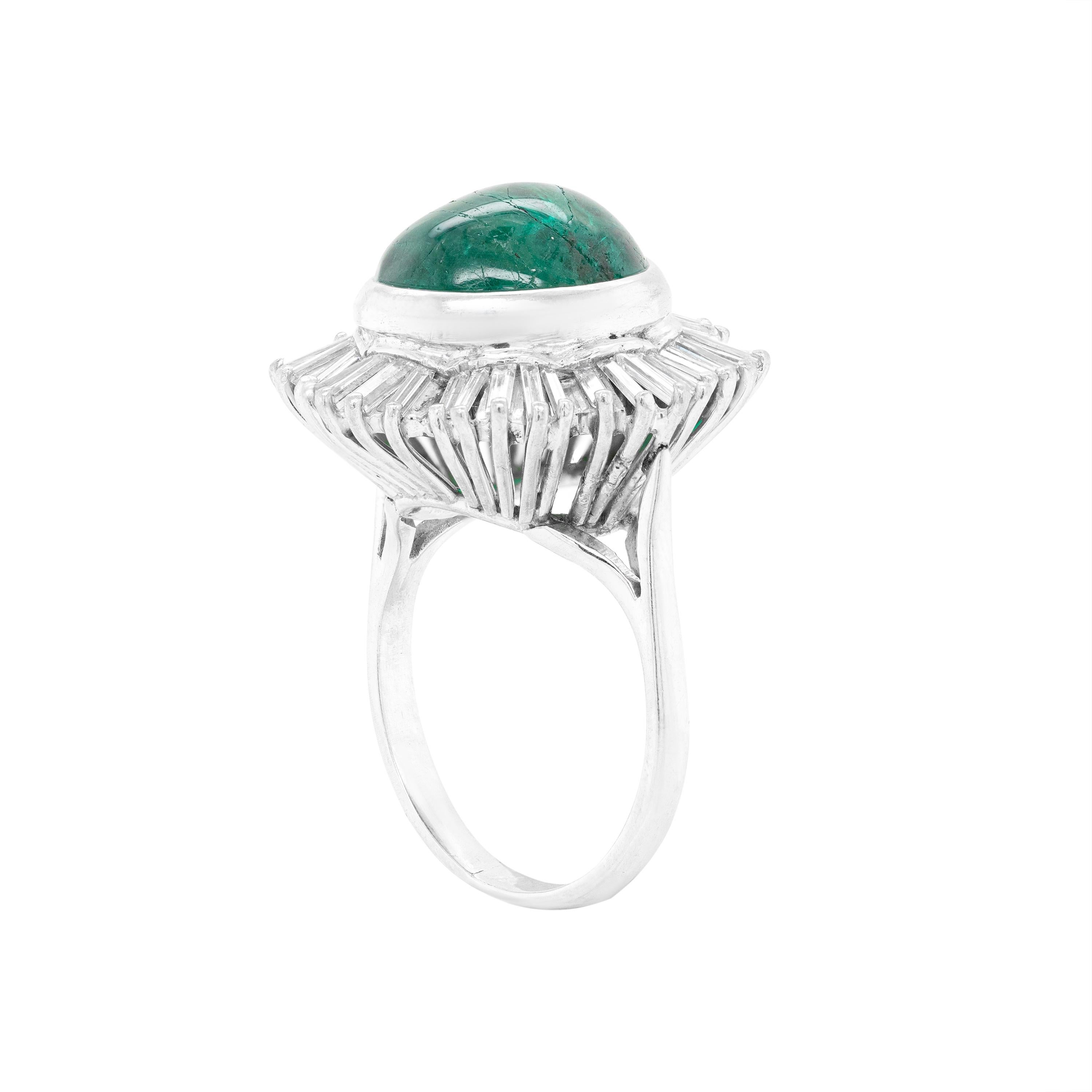This wonderful dress ring features a vibrant cabouchon emerald weighing an impressive weight of approximately 10.00ct, rubover set in an 18 carat white gold, open back setting. The centre stone is beautifully surrounded by 40 baguette cut diamonds