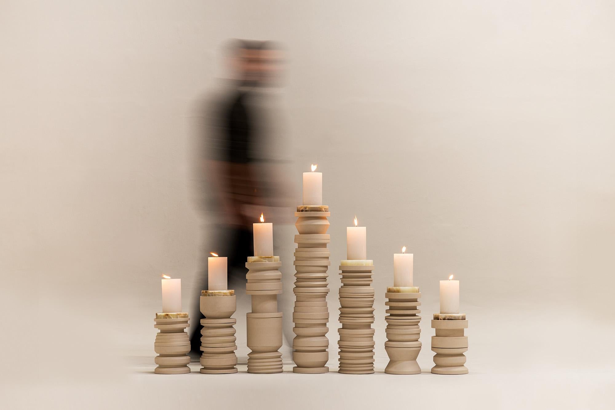 Set of 7 totemic candelabra towers with stepped totemic character. Structured through a system of stackable modules, they allow different variables of height and configuration that result in a low-scale installation. It is the result of the