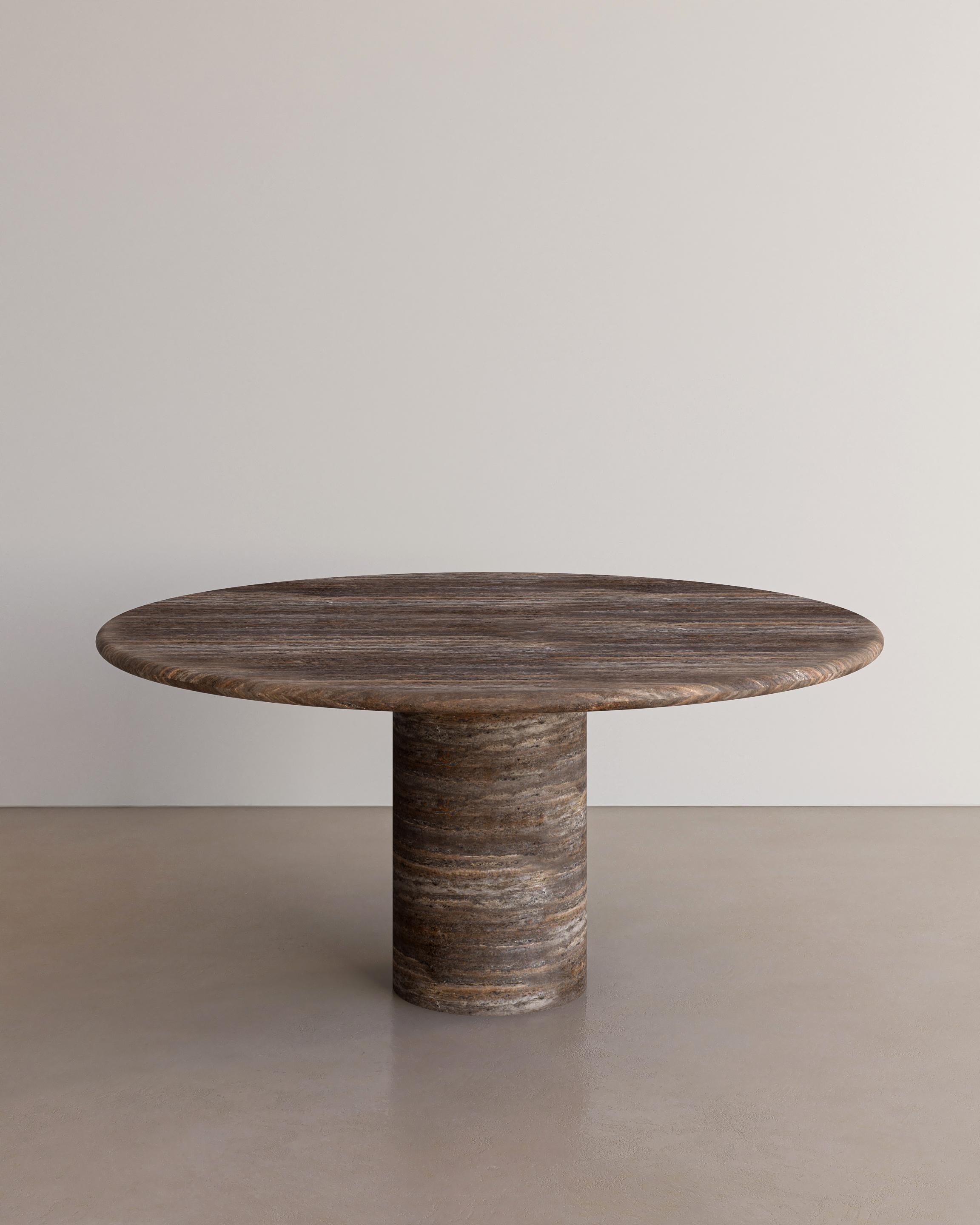 The Voyage Dining Table I in Cacao Travertine with a honed finish by The Essentialist celebrates the simple pleasures that define life and replenish the soul through harnessing essential form. Envisioned as an ode to historical elegance, captured