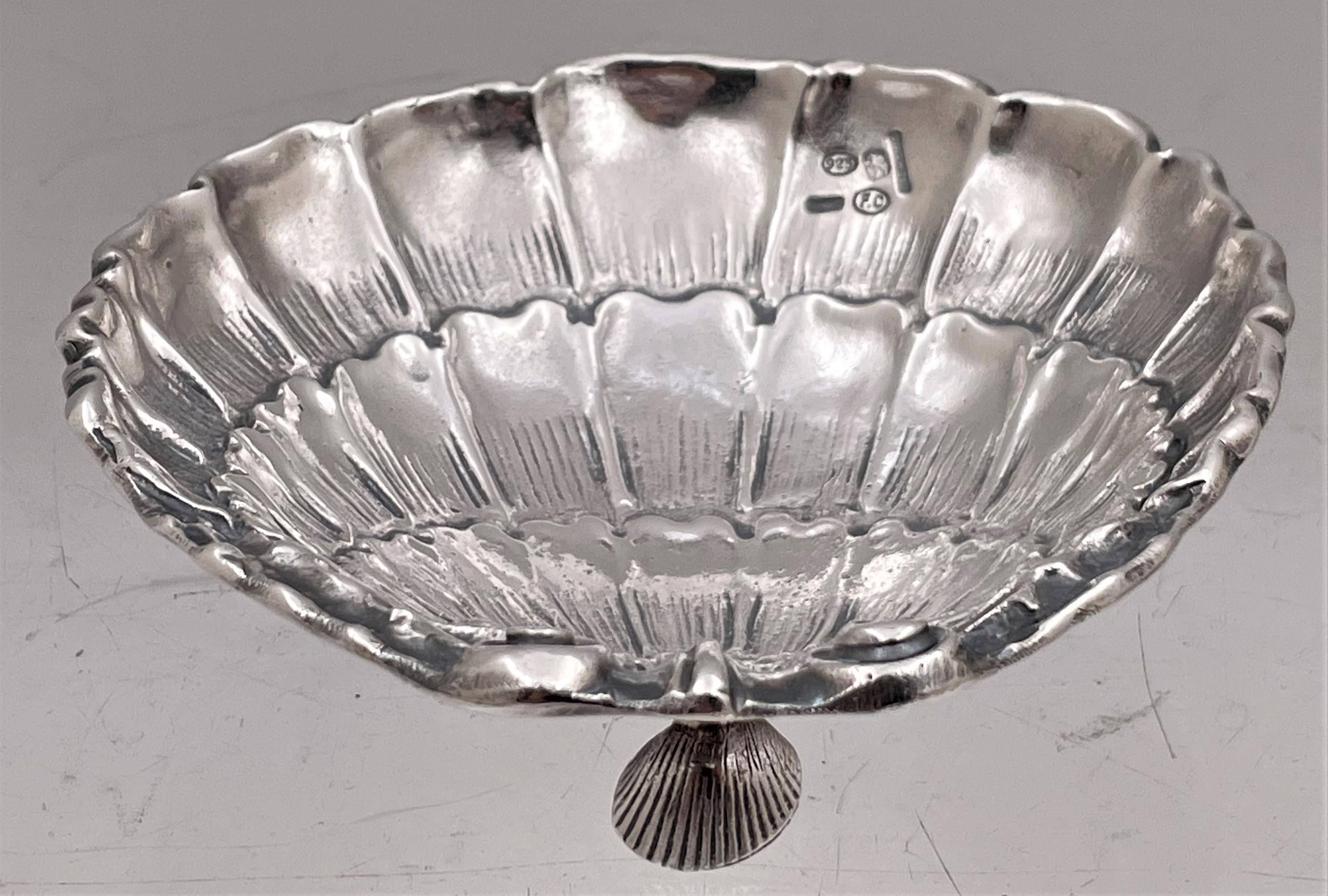 Cacchione, Italian sterling silver nut or trinket dish with a beautiful shell-shaped design, standing on 3 feet shaped as shells. It measures 4 1/8'' in length by 4'' in width by 1 1 /4'' in height, weighs 6.3 troy ounces, and bears hallmarks as