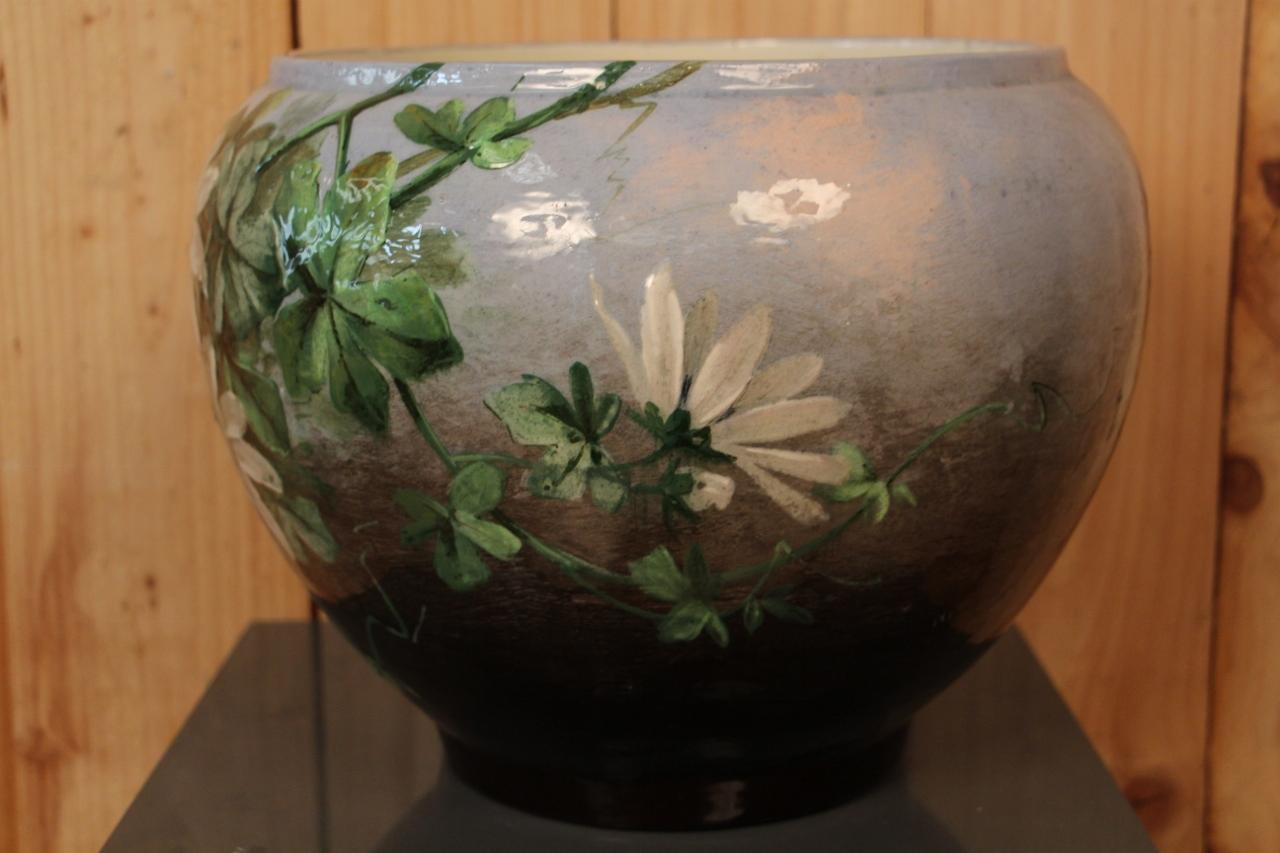 cache pot en céramique émaillée polychrome à décor de fleurs de la passion, signé en dessous et ainsi que dans le décor 
