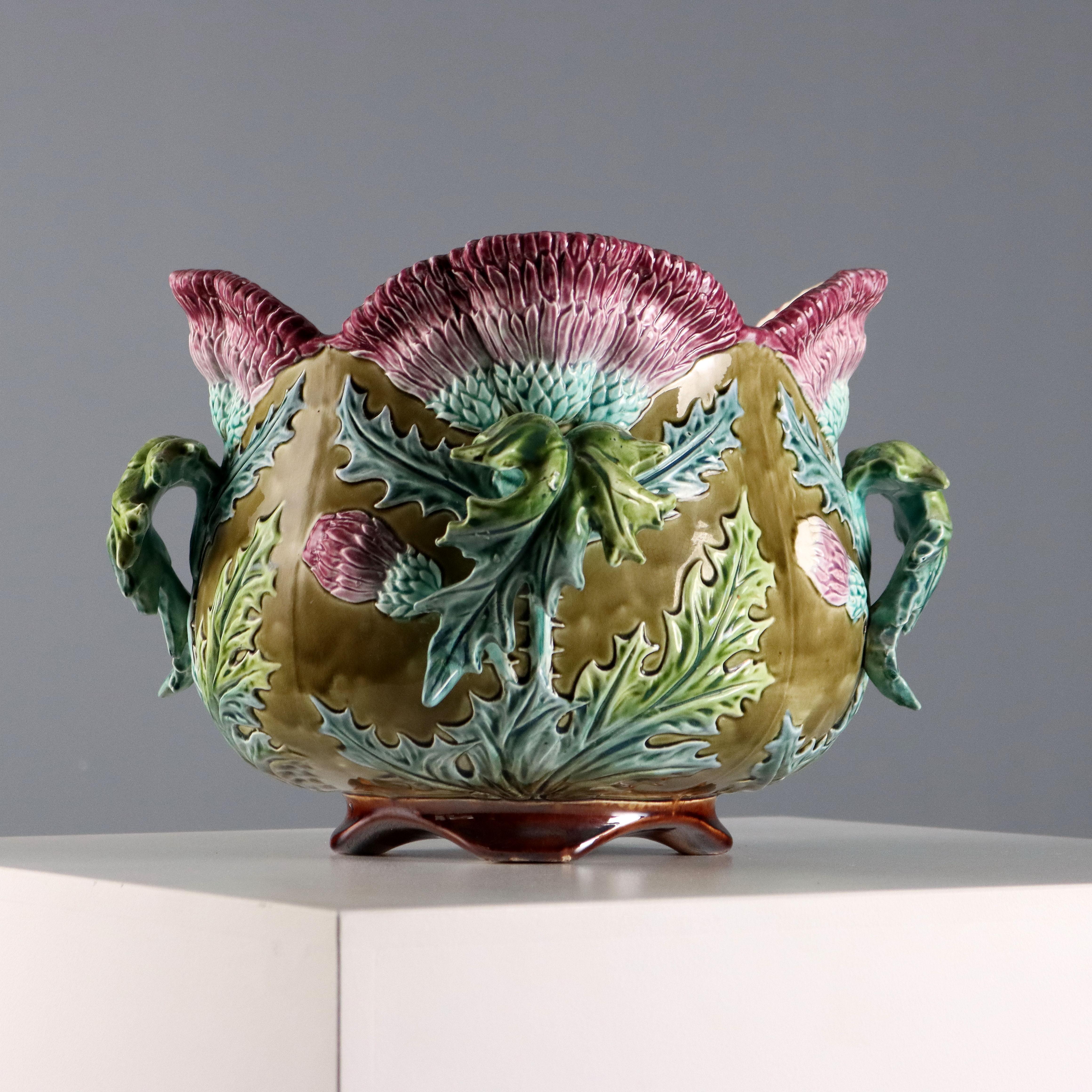 Cache pot in ceramica smaltata. Decoro policromo raffigurante mazzi di cardi e anse a foggia di foglia.