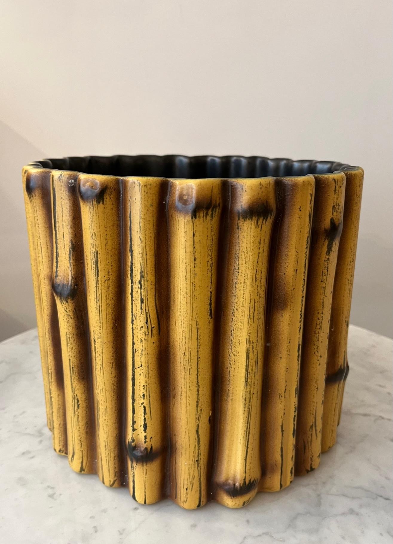 Earthenware cachepot by Pol Chambost (1906-1983) 
Cylindrical form, the body is formed of stylized bamboos 
Glazed with yellow of Naples heightened with ochre and brown, black interior.
Signed underneath : 