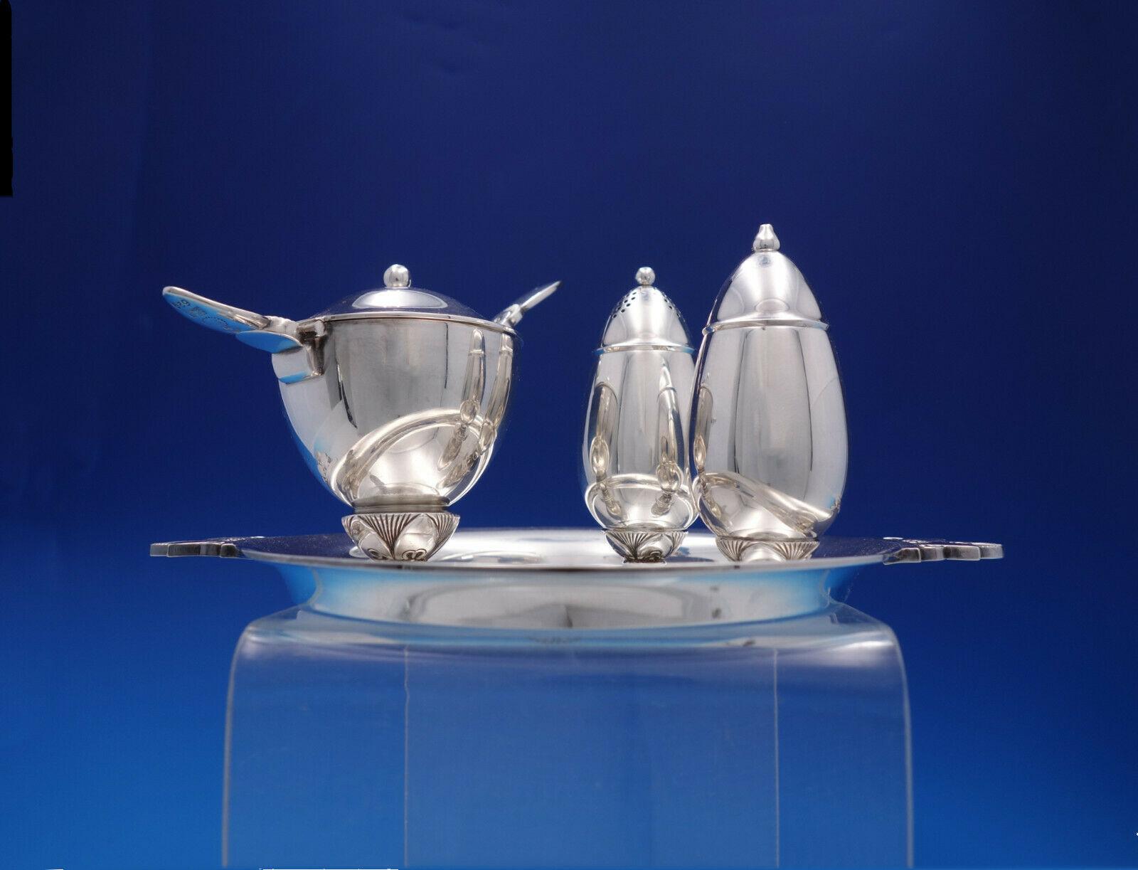 Cactus by Georg Jensen

Gorgeous vintage Cactus by Georg Jensen sterling silver 5-piece Condiment Set including: 1 Mustard Pot, 1 Mustard Ladle w/stainless implement, 1 Salt shaker, 1 Pepper Shaker, and Tray.
The mustard pot with blue enamel is