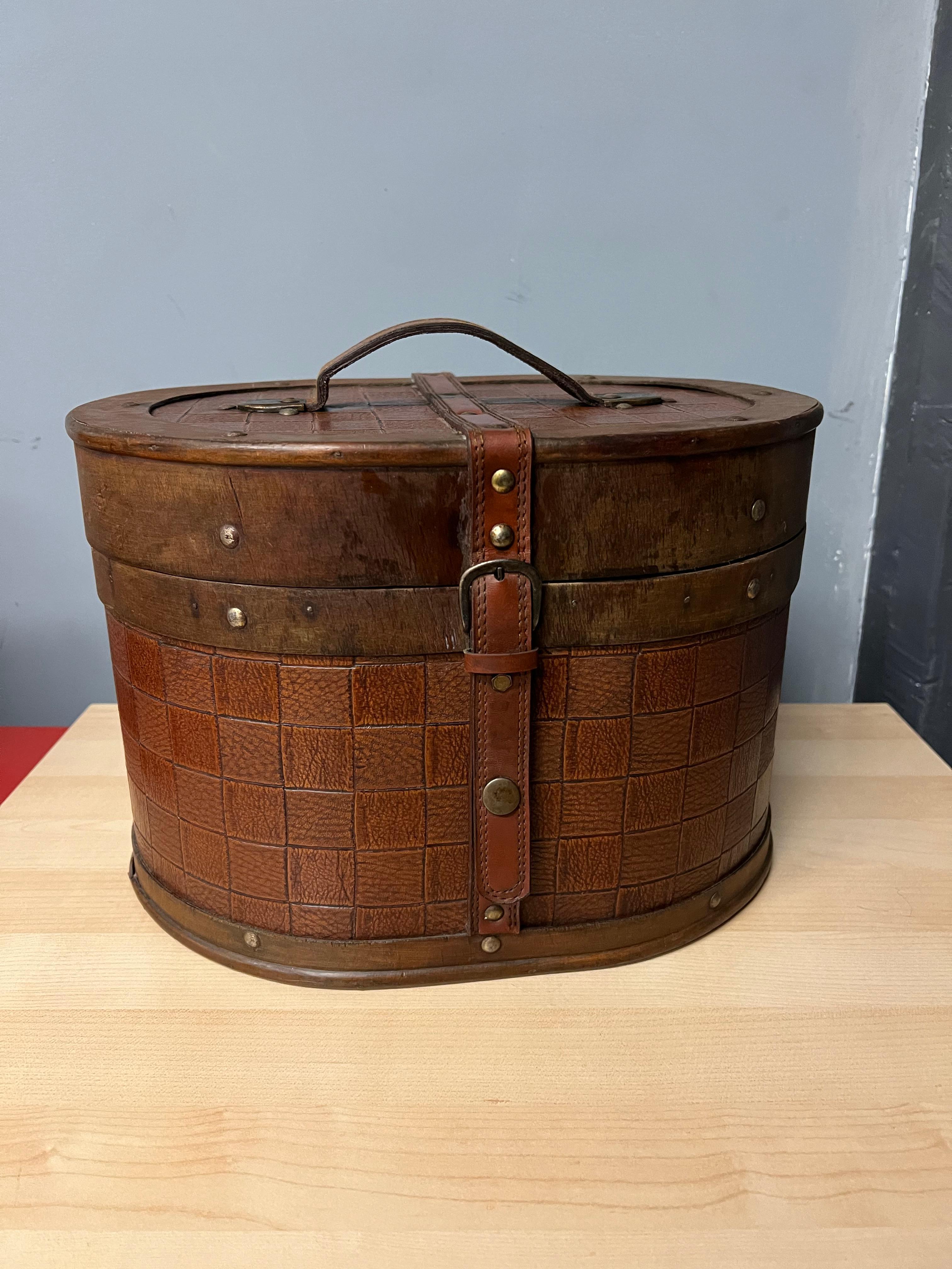 Traveler's caddy or basket with buckle and snap closure Durable vinyl outer has a woven-leather look to it. This piece has a handle on top for easy carrying. Interior is fabric. This piece is a compliment to any room, for decorative purposes or for