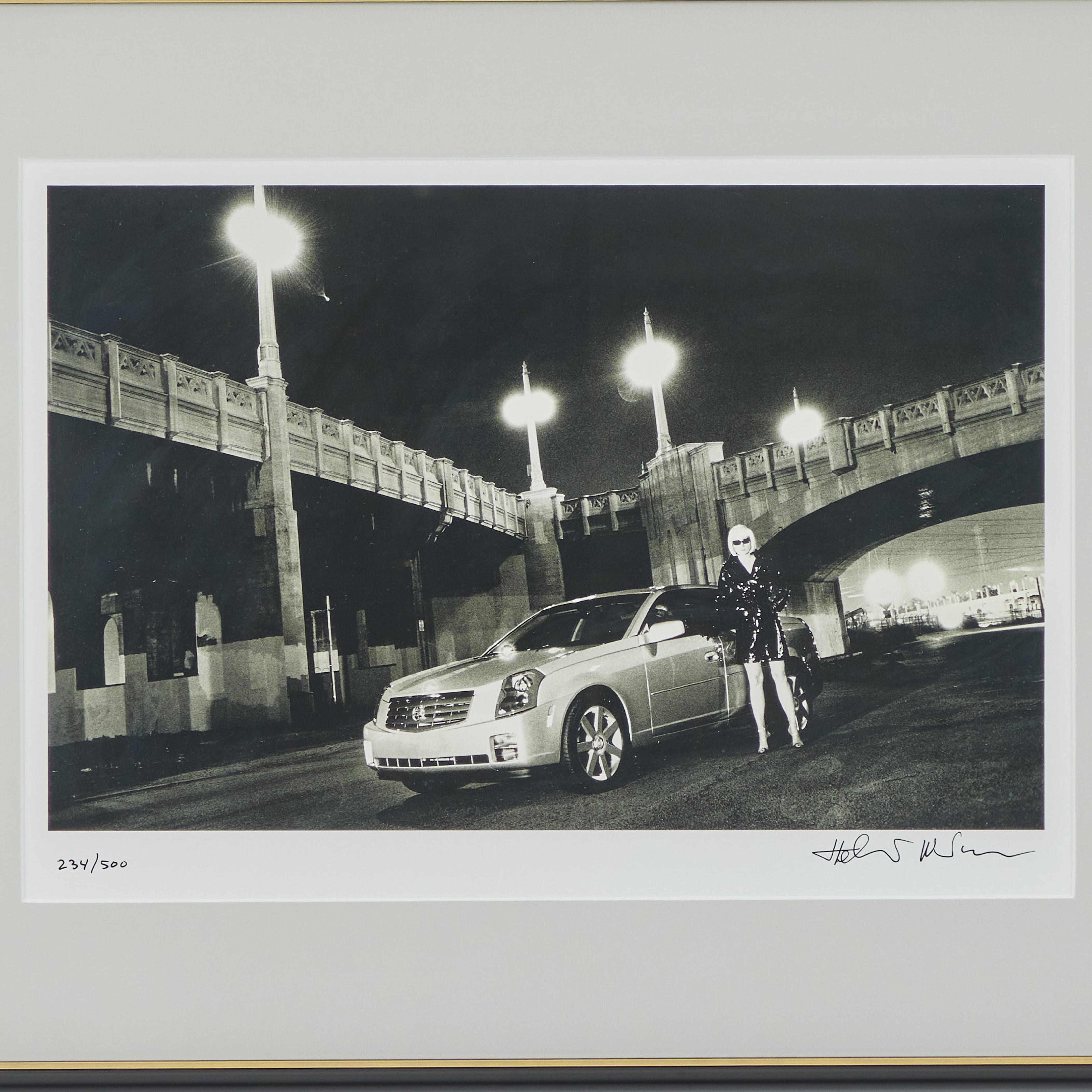 Il s'agit d'une fabuleuse photo prise par le photographe de renommée mondiale Helmut Newton. Cette image a été commandée pour une Cadillac/GM en 2002.  Il a été offert à des acteurs importants du monde de Cadillac. La voiture et la blonde Evi,