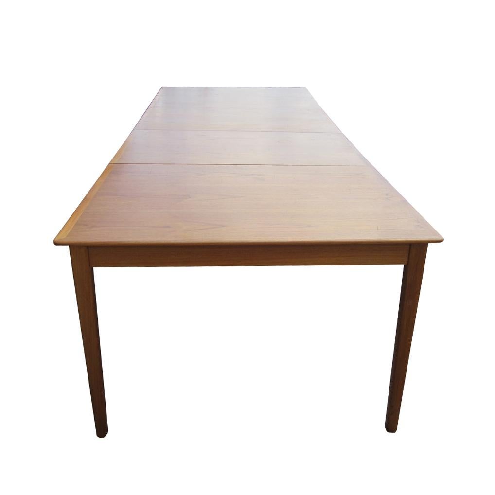 A sleek Danish dining table with two leaves by Cado. Extremely versatile, with an adjustable fifth leg for extra stability, this dining table can comfortably seat anywhere from four to ten guests, for either an intimate dinner or a dinner party.  
