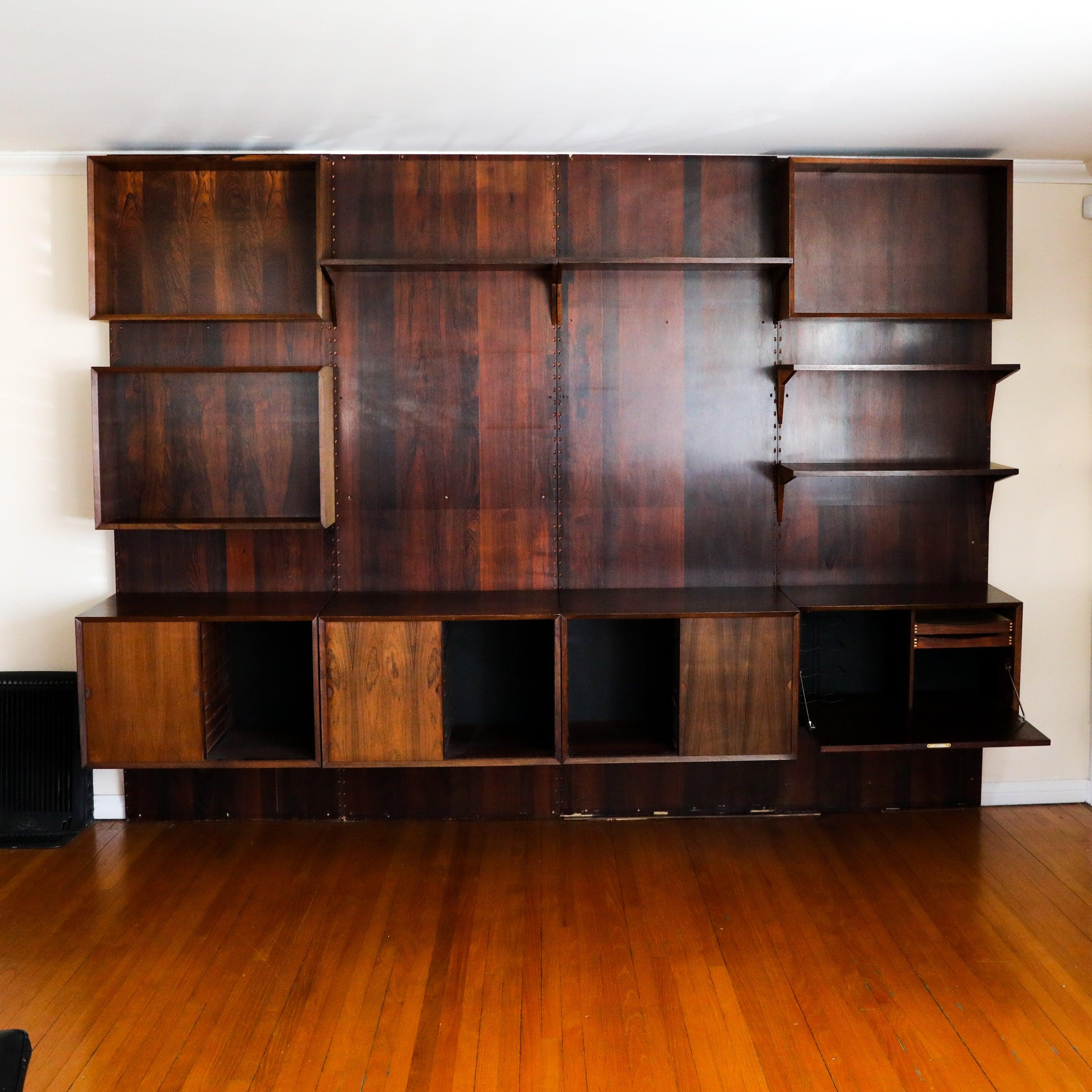 **Prices inclusive of restoration** Price does not include installation. 

Mid Century Modern Brazilian Rosewood Cado Wall Unit. This vintage unit is completely modular and in excellent shape for its age. It has endless possibilities as to where you
