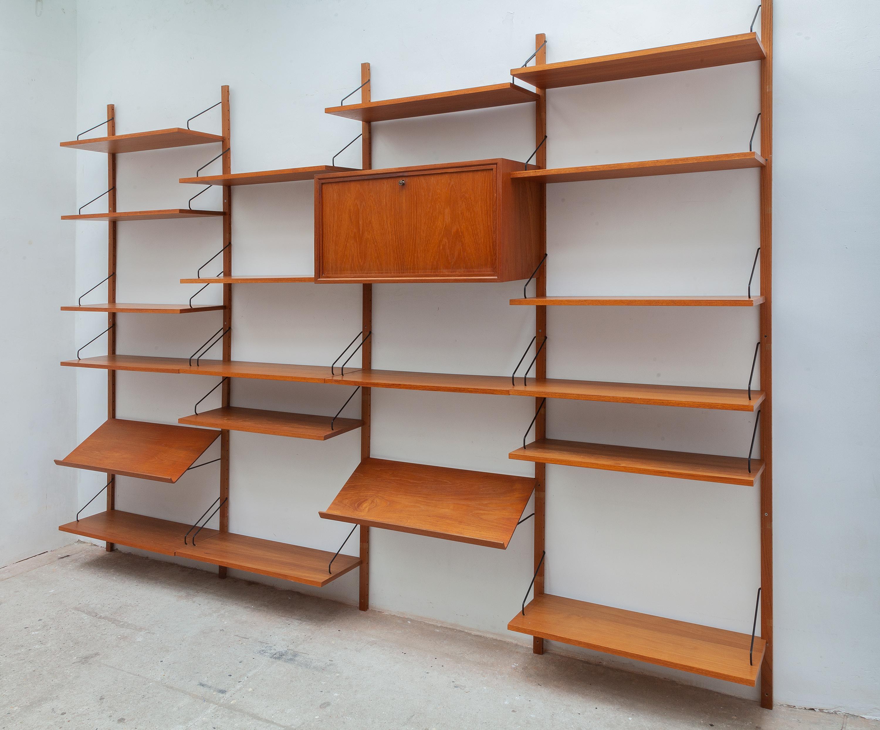 Vintage Midcentury Danish wall unit designed by Poul Cadovius Royal System with solid teak brackets. Five wood rails suspend five cabinets, has maker’s stamp. Well designed modular system with many movable shelves includes the hard to find magazine