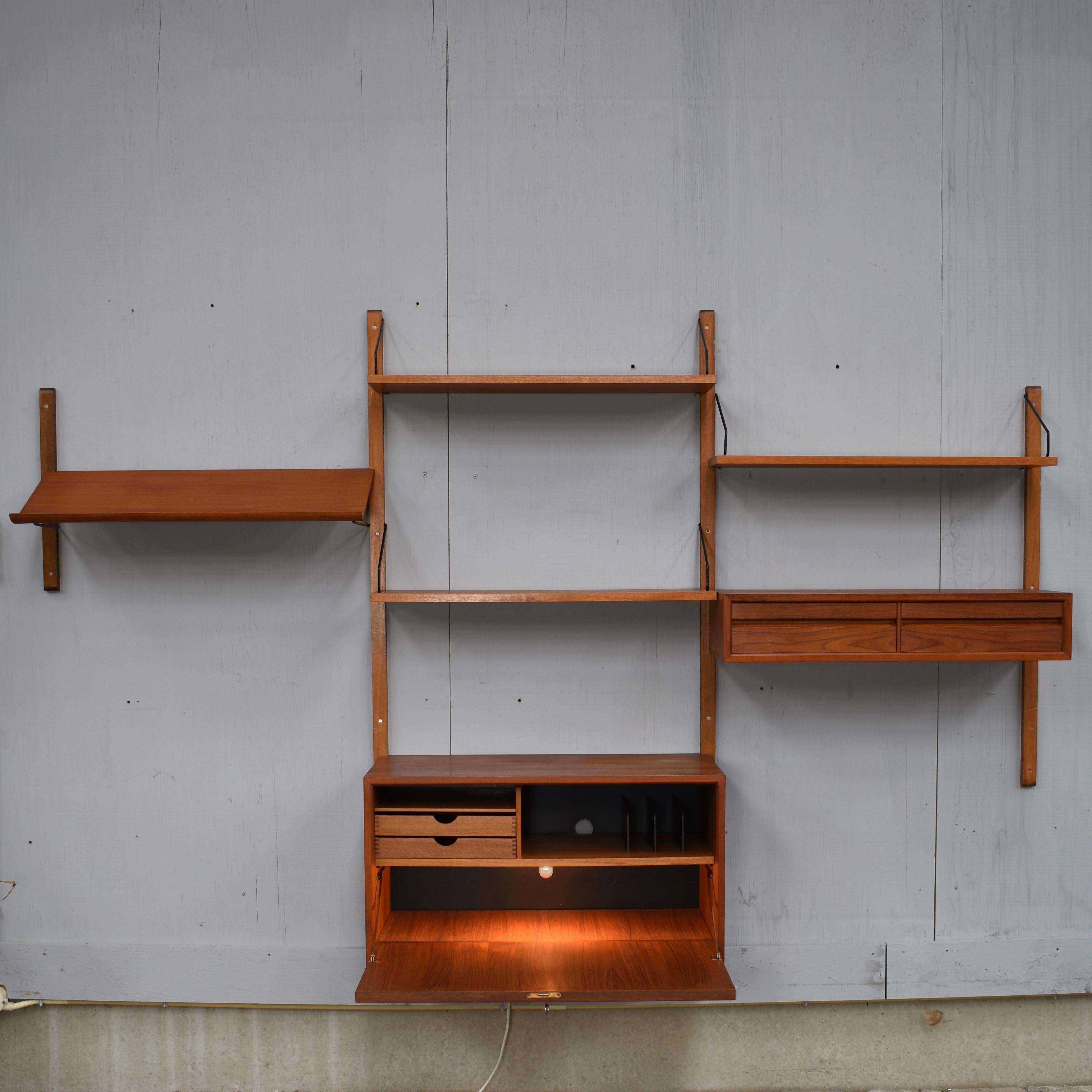 Beautiful Royal series wall unit by Poul Cadovius with much wanted angled lecture shelve. In a beautiful warm wood color and in good condition.
This unit features:

– 1 much wanted lecture shelve

– 1 desk cabinet with built-in light

– 1