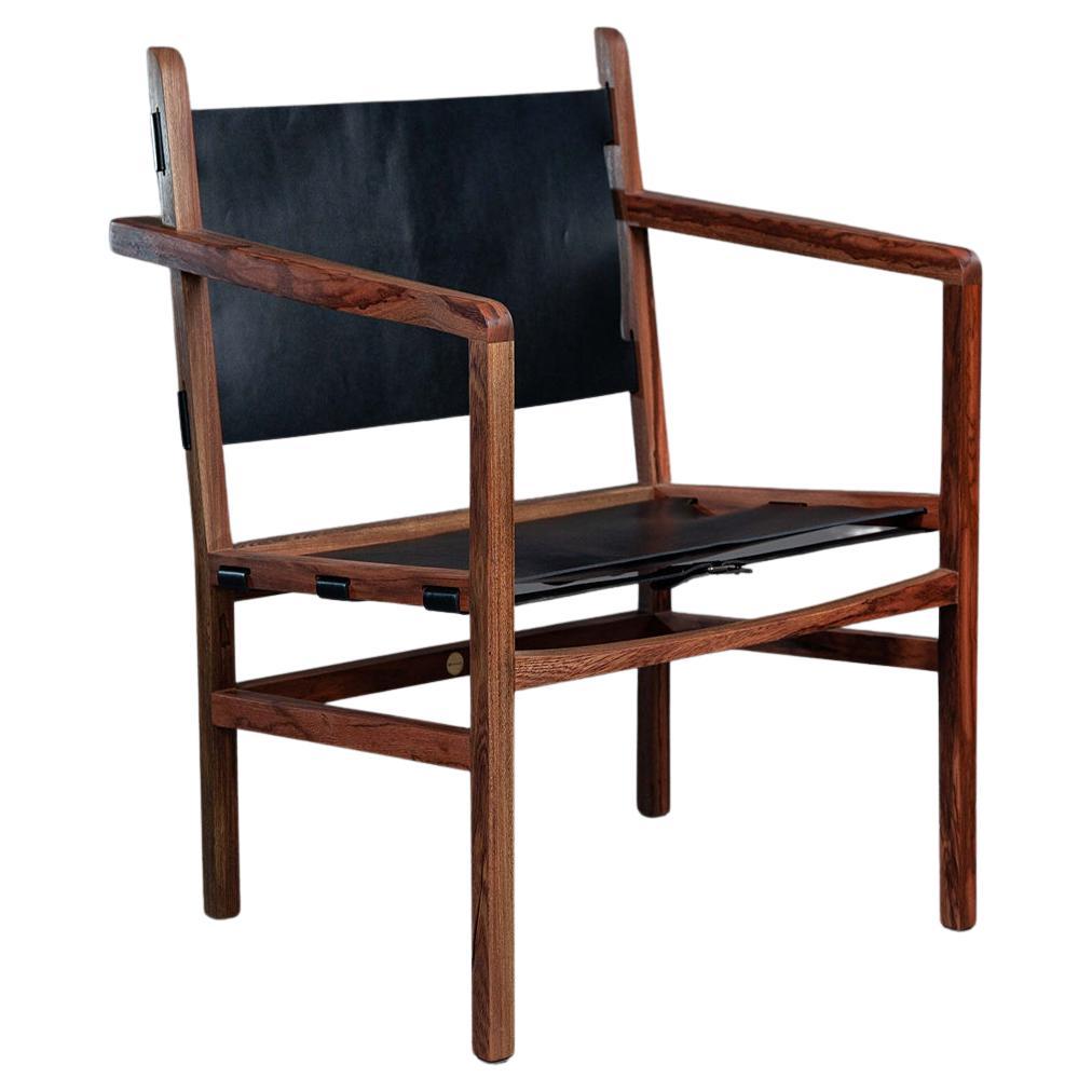 Le fauteuil Caetano Charm et confort en bois de fer massif et cuir. en vente