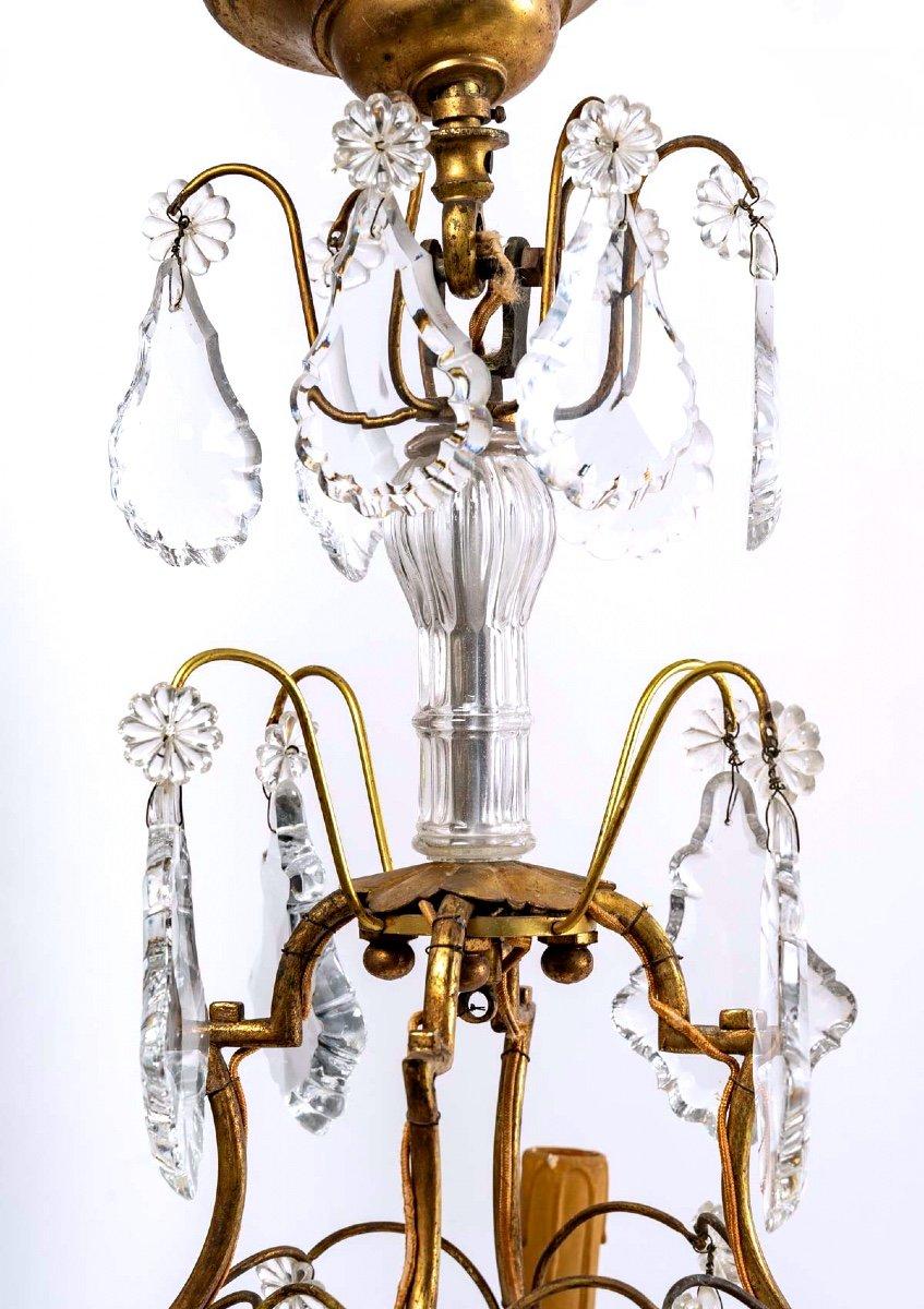Charming cage chandelier with four arms of light.
The light and airy gilded bronze frame is enhanced by the brilliance of the large cut crystal pendants and daisy-like pendants.
Period: 20th century
Style: Louis XV
Dimensions: Height: 70cm -