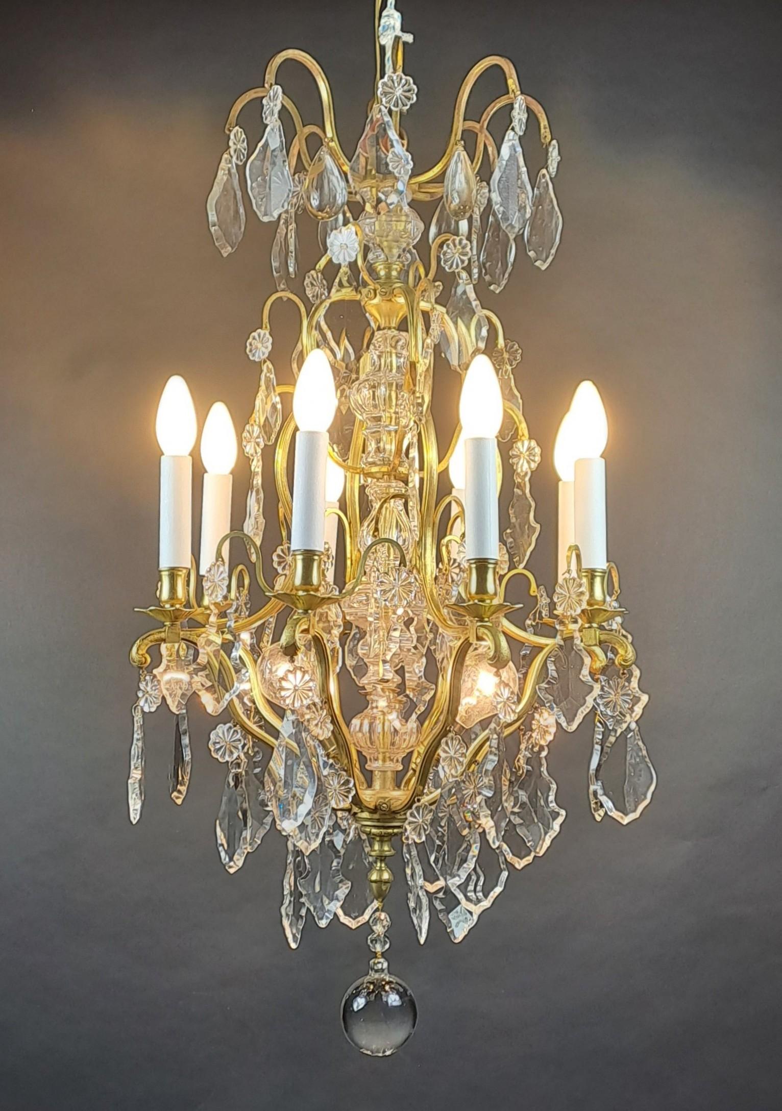 Magnificent Louis XV style cage chandelier in gilded bronze very richly decorated with crystal pendants from the Baccarat crystal factory.
Iluminating with eight arms of light and two points of light in the center

French work from the end of the