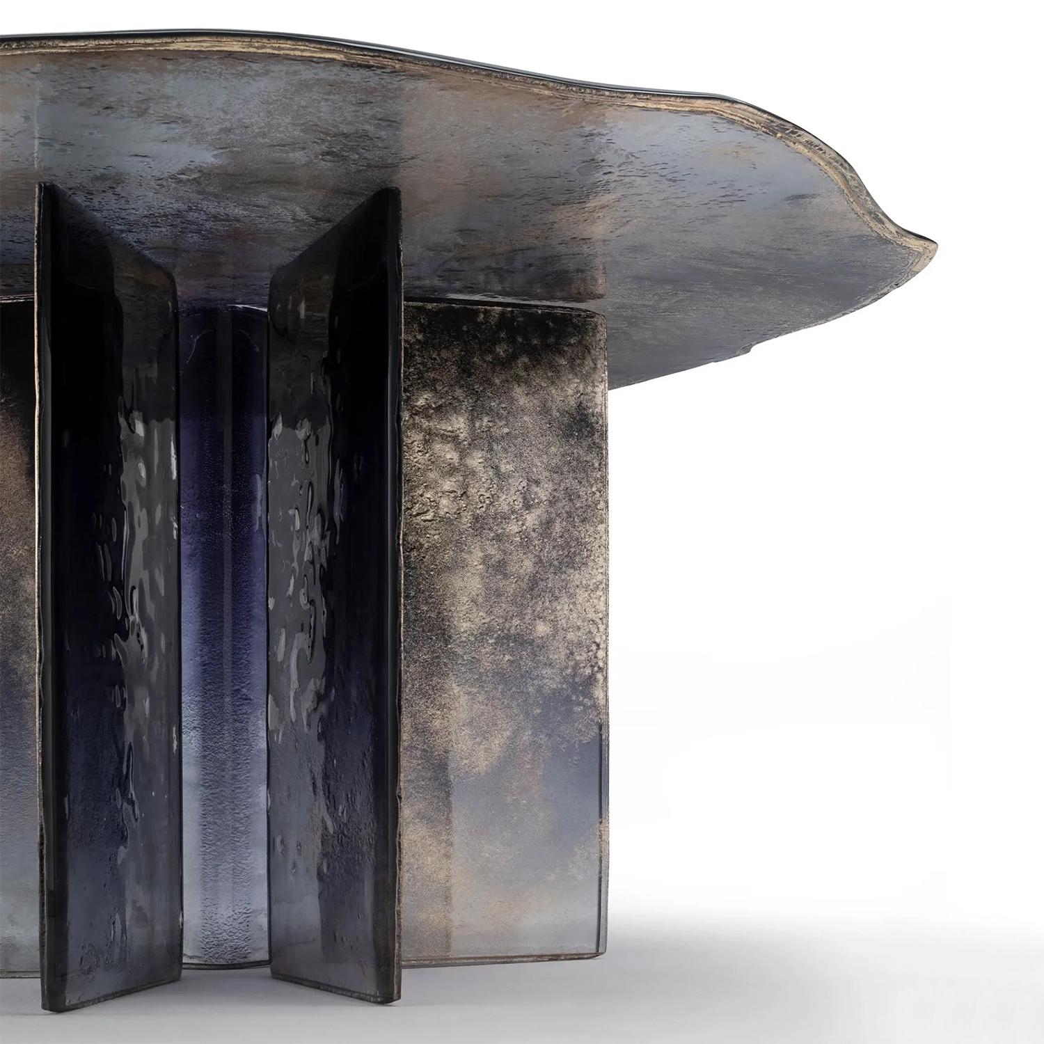 Table Cagilari Round tout en verre cuit en 2 couches. Plateau de table avec 
des bords irréguliers. Toutes les pièces en verre sont vernies avec un dégradé de 
bleu foncé à transparent avec dos partiellement argenté.

