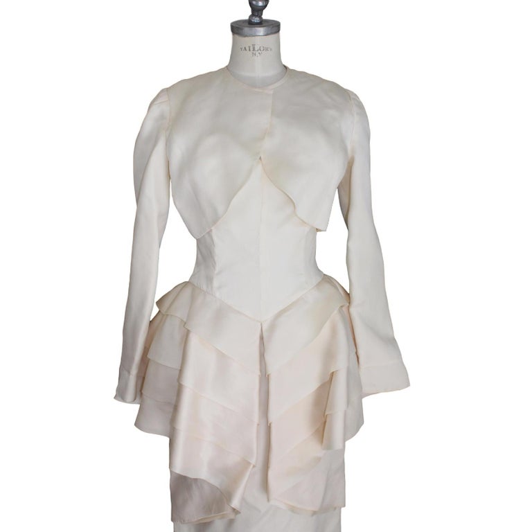 Vintage beige wedding dress silk sheath dress with three leaps at the waist with padding and long-sleeved bolero jacket.

The wedding dresses, have been used for fashion shows, are in good condition and must be washed.

SIZE: 44 It 10 Us 12