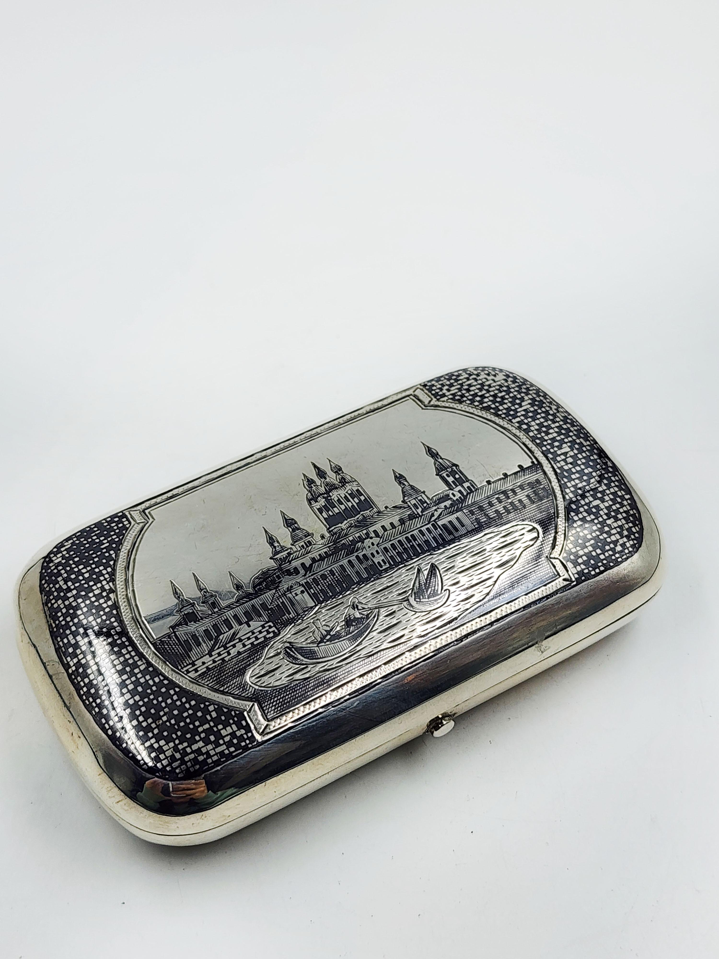 Russian Silver and Nickel Tobacco Box, 19th Century
Beautiful first-class Russian silver cigar holder, with a nickel-engraved design that represents a landscape with historical buildings, with a body of water with boatmen, on the edge of the lid it