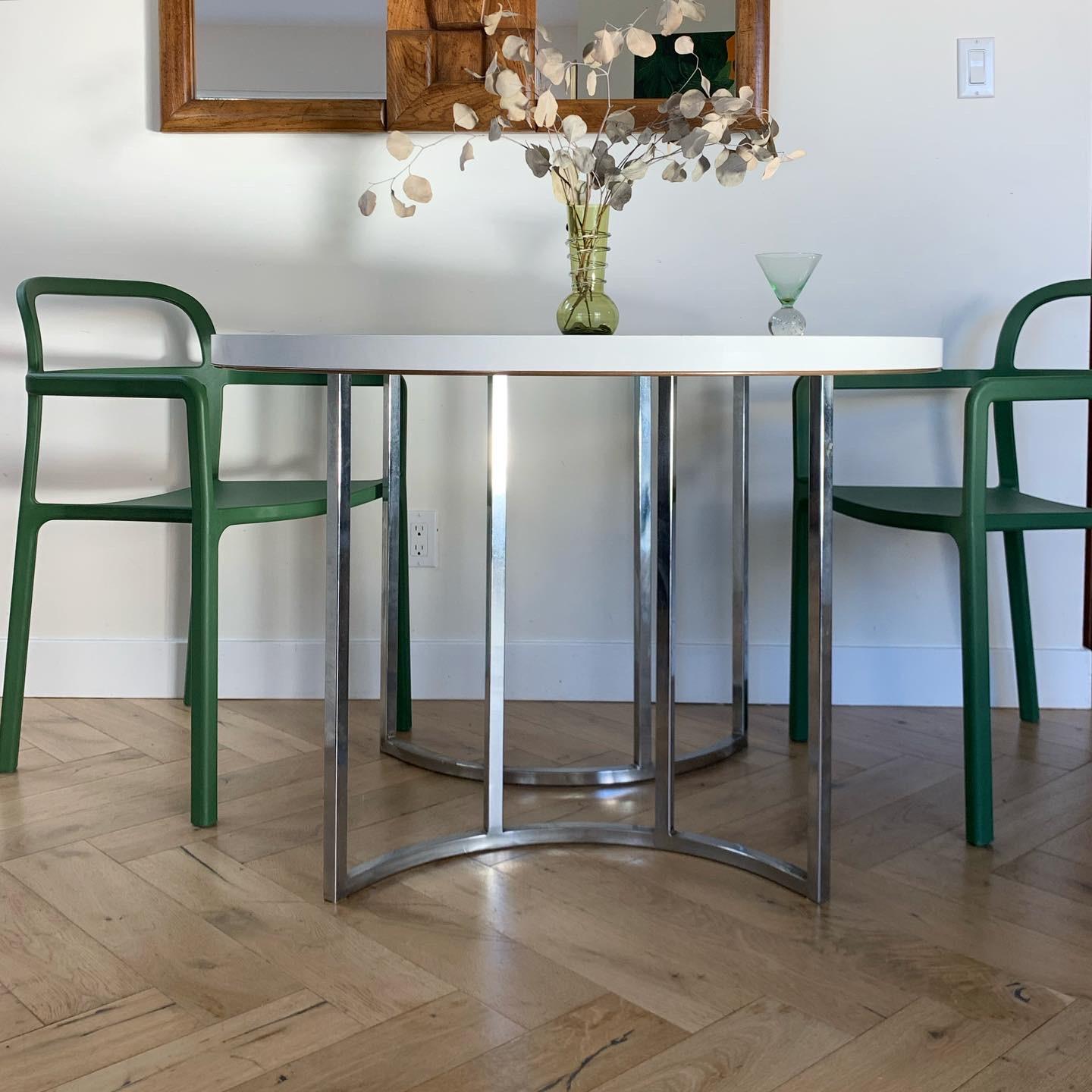 Early 1970s dinette bistro dining table with geometric chrome double pedestal base and laminate round top. Local pick up and delivery available.