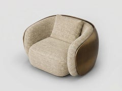 Sillón Cala con forma redondeada tapizada y carcasa exterior escultural