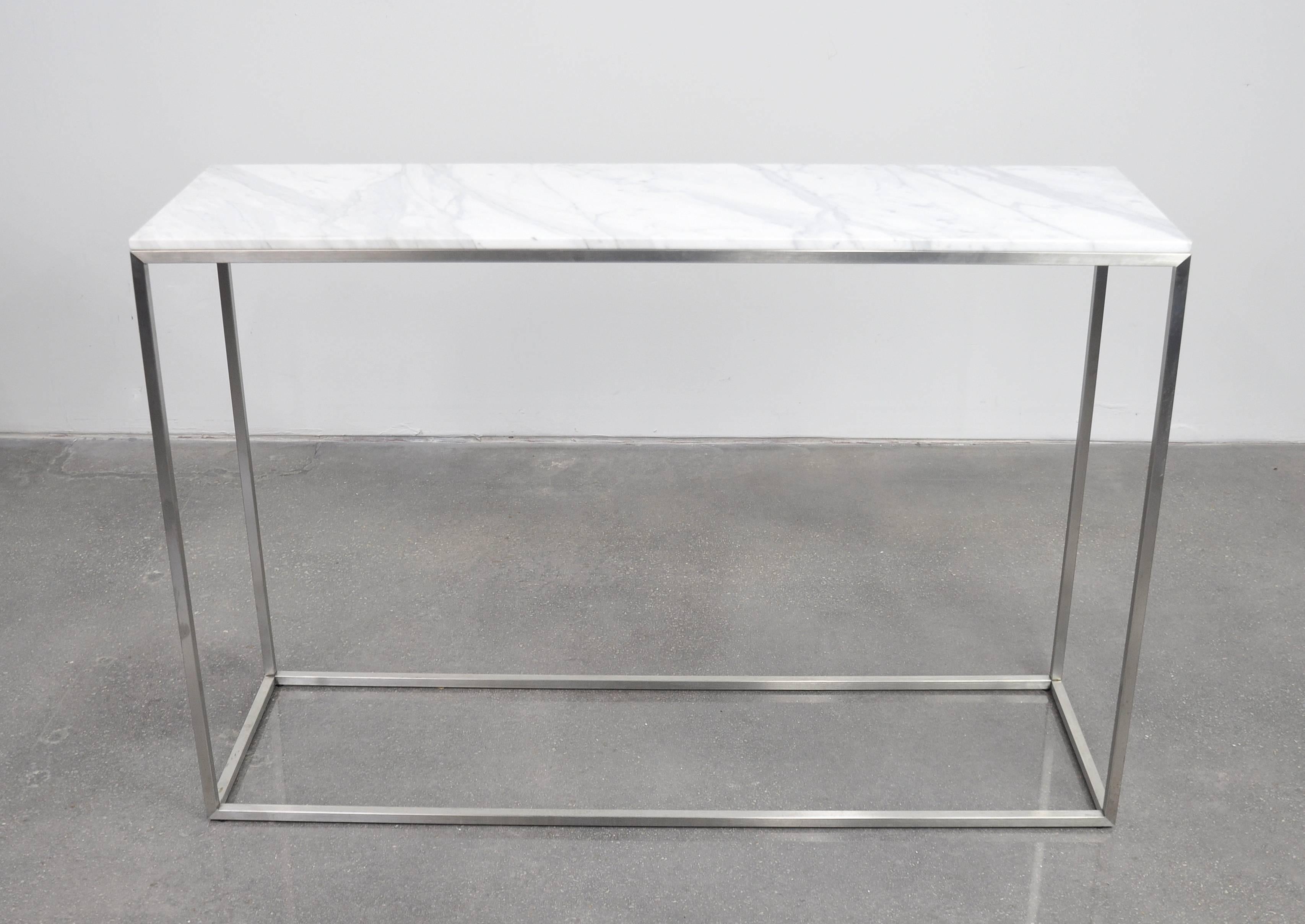 A contemporary occasional table featuring a beautiful white with light grey veins rectangular Calacatta Carrara marble top over a Minimalist brushed aluminum metal frame. The table can be used with either the honed (matte) marble side or the