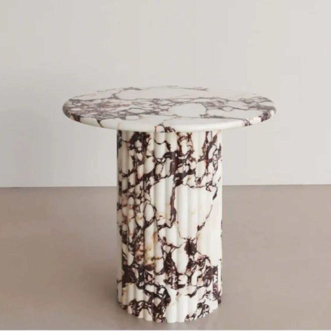 The Calacatta Viola Marble Side Table with Fluting is a remarkable piece of furniture that exudes both luxury and sophistication. Crafted from premium Calacatta Viola marble, it boasts a striking combination of timeless elegance and captivating