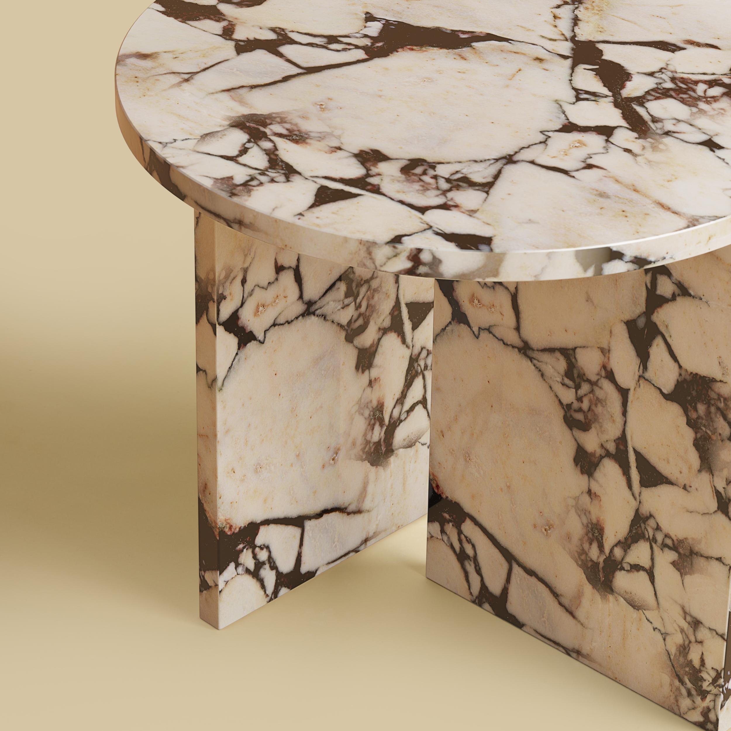 La table basse Kyushu est entièrement réalisée en marbre violet calacatta. Le plateau est circulaire et mesure 45 cm de diamètre. La luxueuse table d'appoint en marbre violet Calacatta rehausse votre espace. Entièrement fabriquée en marbre Calacatta