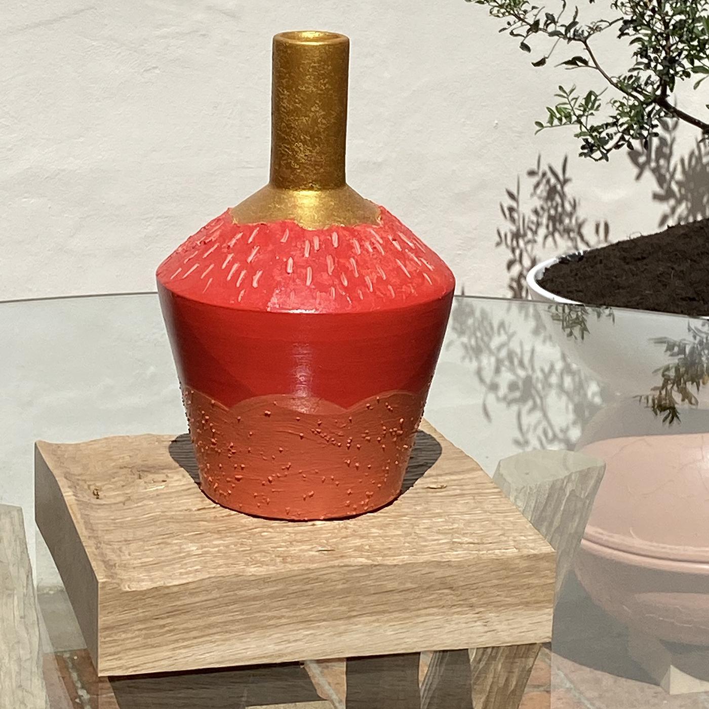 This biscuit terracotta vase is hand-turned for a wonderfully rustic allure. Its hand painted design combines a mixture of artisanal techniques, featuring an orange base, red middle and gold neck. Set on a sculpted solid oak base for a final rustic
