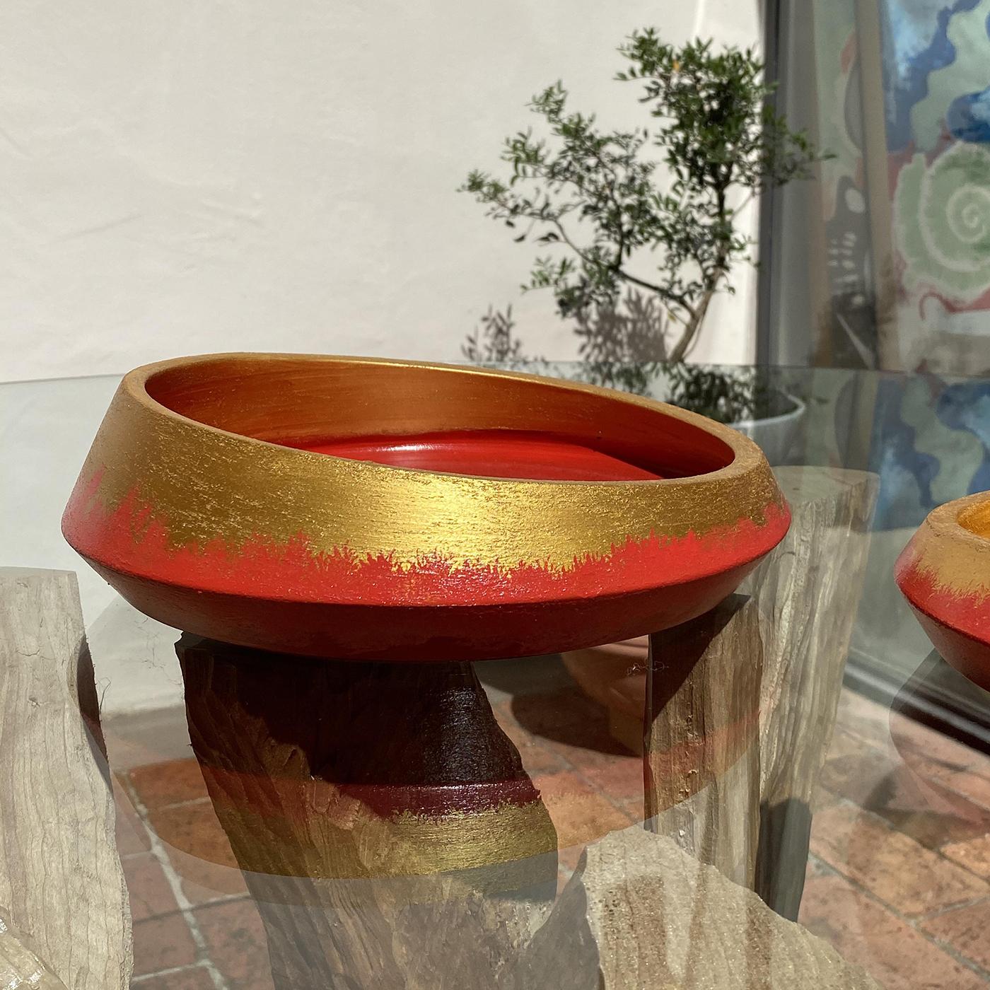 This set of two hand turned vases are crafted from white biscuit terracotta. Hand painted for a wonderfully rustic allure, their matching designs combine a fiery red base with luxurious gold edging. The Calafuria Sei 2 Vases by Mascia Meccani adds