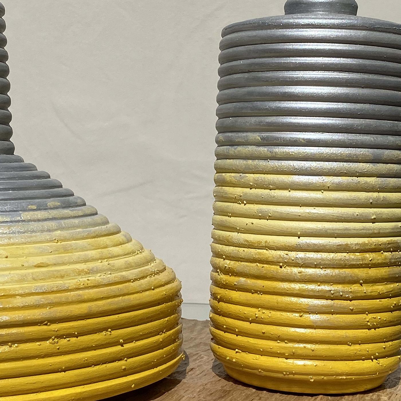 The Calafuria Tre 2 vases by Mascia Meccani makes a rustic addition to the home. The two hand-turned biscuit terracotta vases are characterized by an unusual ribbed texture, hand-painted in yellow and silver with a decorative gradated effect. Set on