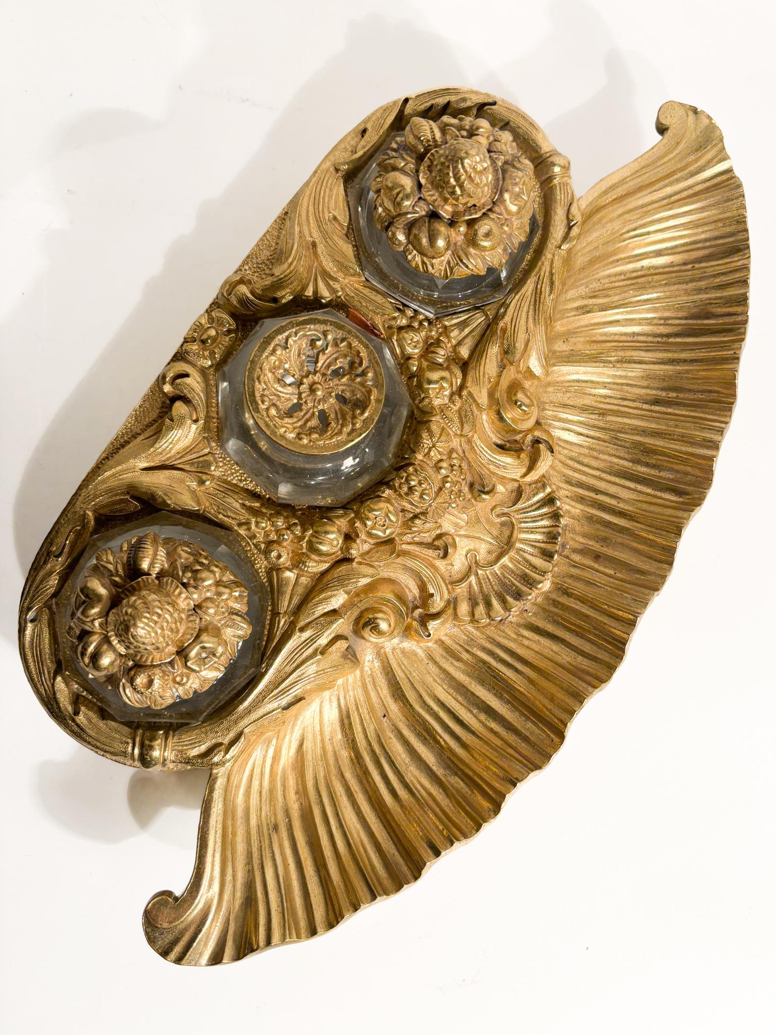 Tintero de bronce dorado y frascos de cristal, fabricados en el siglo XX. Uno de los frascos tiene un chip en la parte de enroscado de la tapa, como se muestra en las fotos. 

Ø 32 cm Ø cm 17 h cm 9

Un tintero triple antiguo es un objeto de