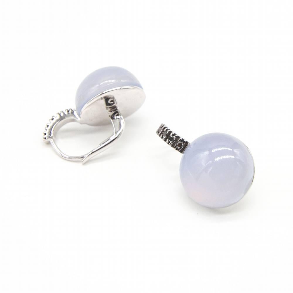 Ohrringe aus Weißgold und schwarzen Diamanten für Frauen  2x 14mm Chalcedonias im Cabochon-Schliff  10x schwarze Diamanten im Brillantschliff, Gewicht ca. 0,10ct  Monacale-Verschluss  18K Weißgold  9,45 Gramm.  Maße: Länge 22mm, Breite 14mm 