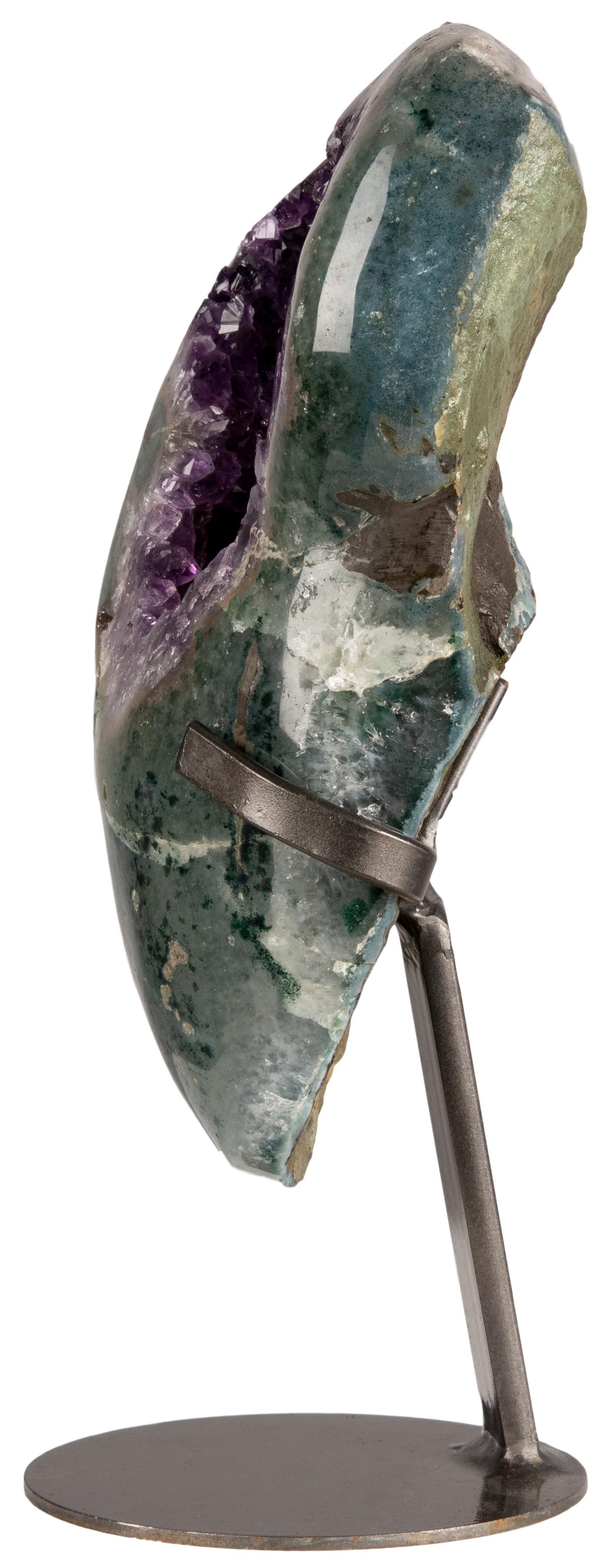 An interesting and stunning geode section with a striking colour mix. 

In this aesthetic piece the original basalt has been polished to reveal the exquisite green celadonite hidden within on the front, whilst maintaining its rough condition at