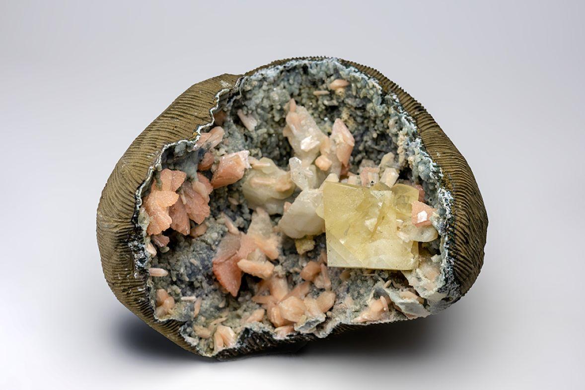 A massive, 52 lb geode with large rhombic Calcite crystals beside a pseudomorphic quartz after Calcite crystals with pink Heulandite crystals in a wheat sheave aggregate.  Additionally, there are lustrous pink Stilbite crystals on gradient